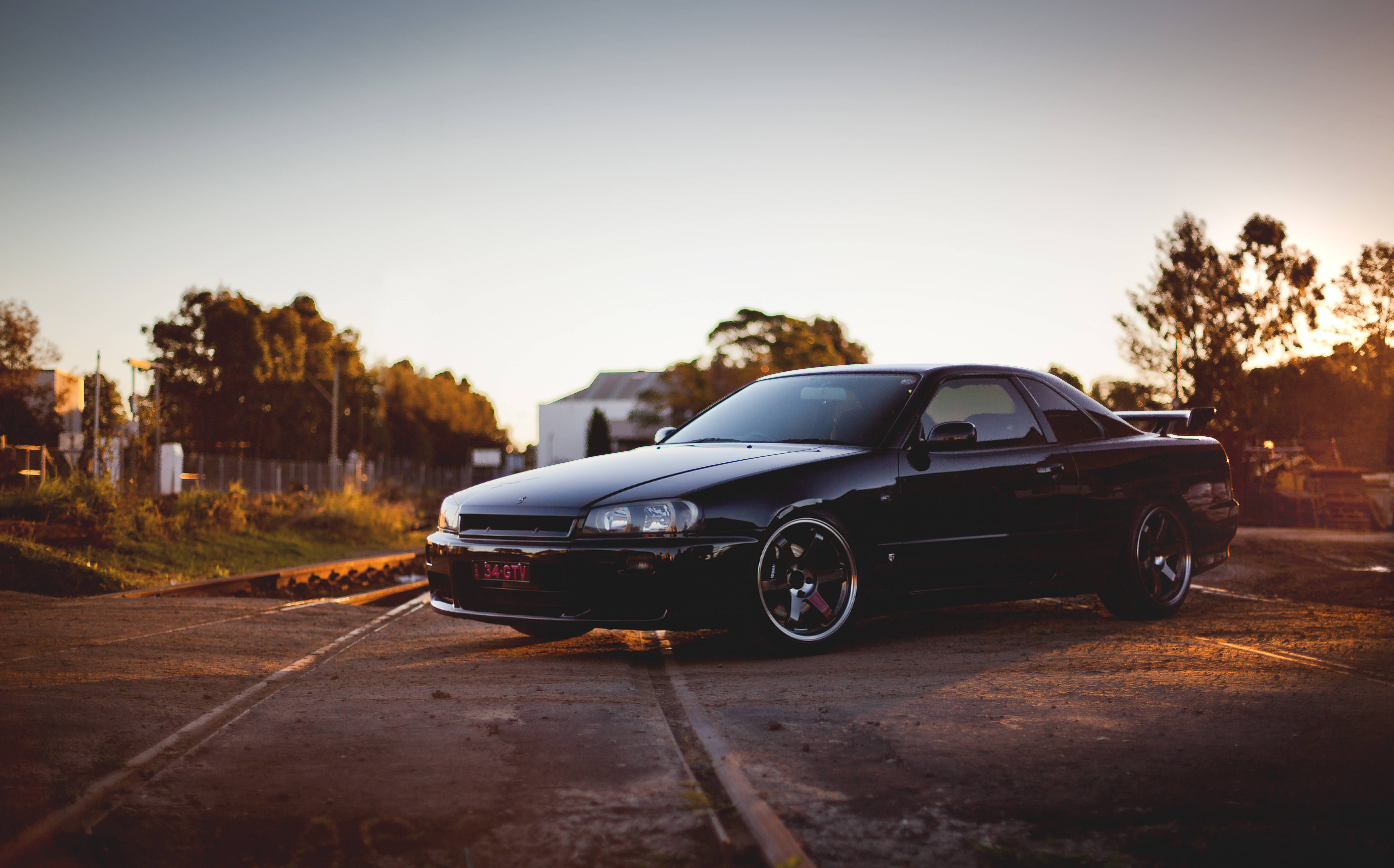 Nissan Skyline GTR R34, railroad, cracked asphalt lot, 5K Desktop Wallpaper