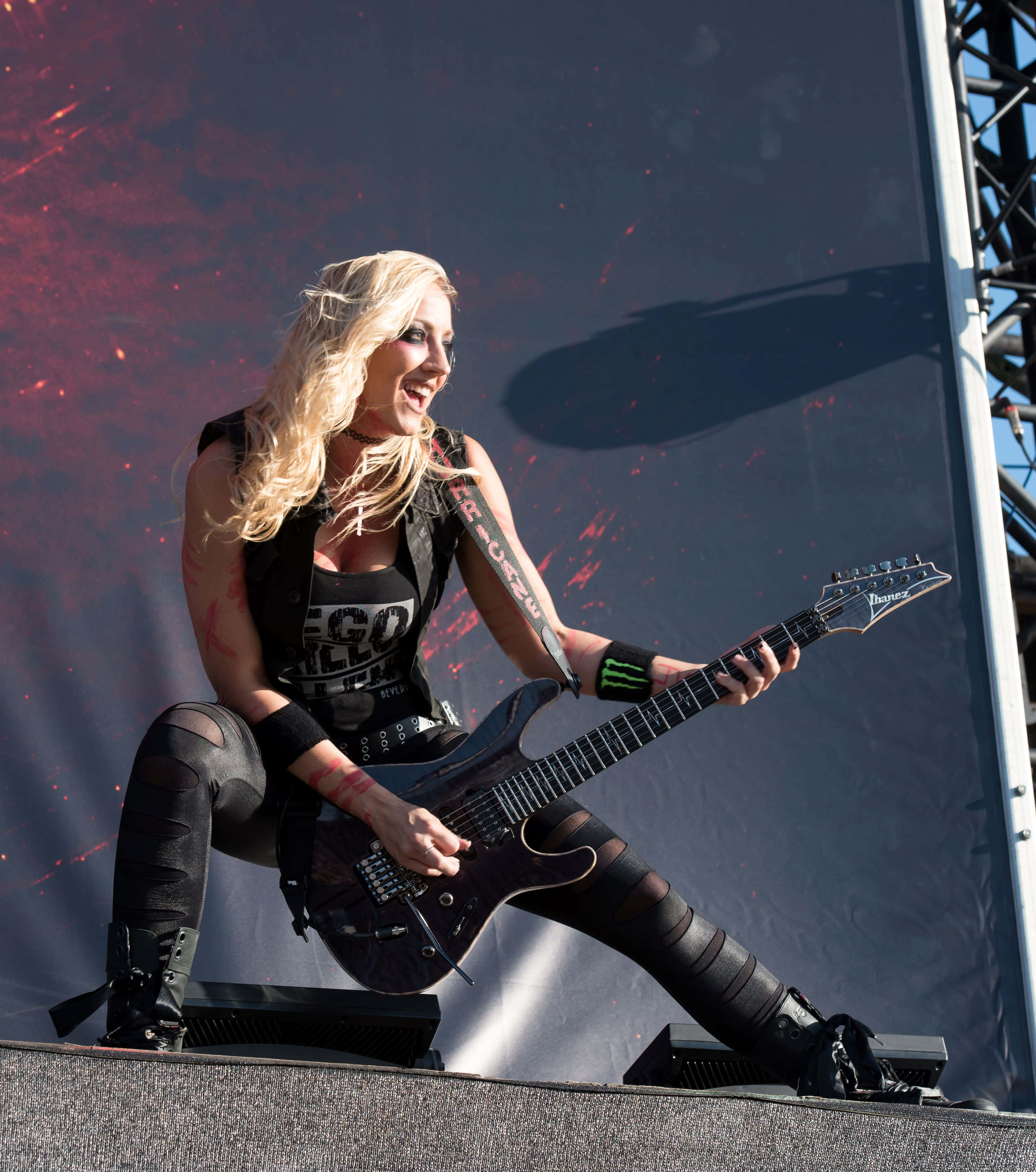 Nita Strauss, black Ibanez guitar, red splatter backdrop, 4K Phone Wallpaper