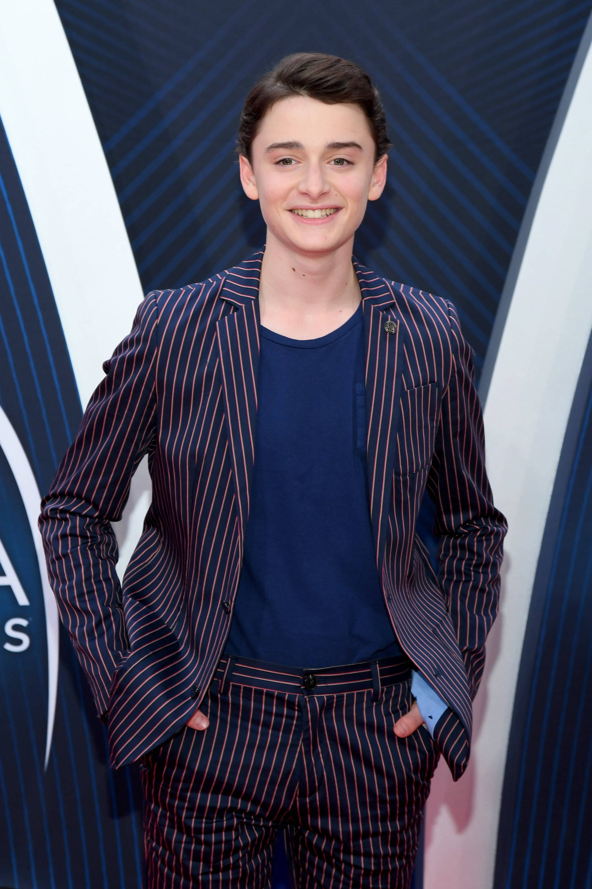 Noah Schnapp, pinstripe suit, geometric blue and white backdrop, 2K Phone Wallpaper