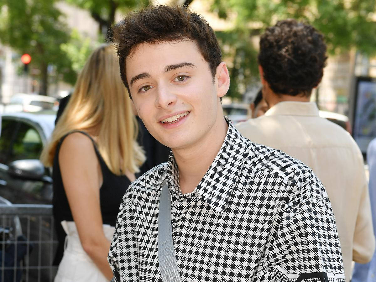 Noah Schnapp, black and white houndstooth shirt, sunlit city street, SD Desktop Wallpaper