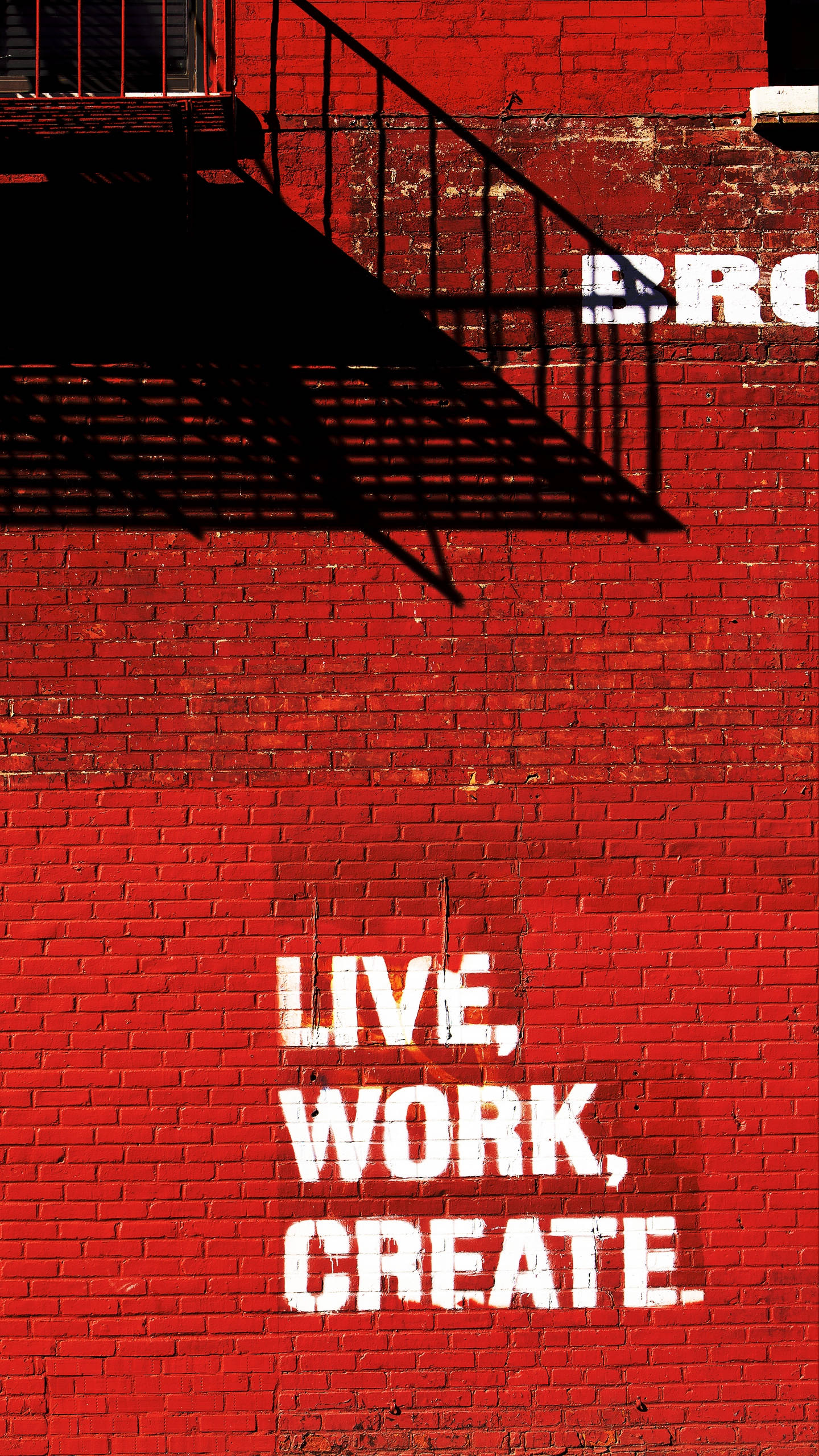 Note 10 Plus, vibrant red brick wall, stark black fire escape shadow, 2K Phone Wallpaper