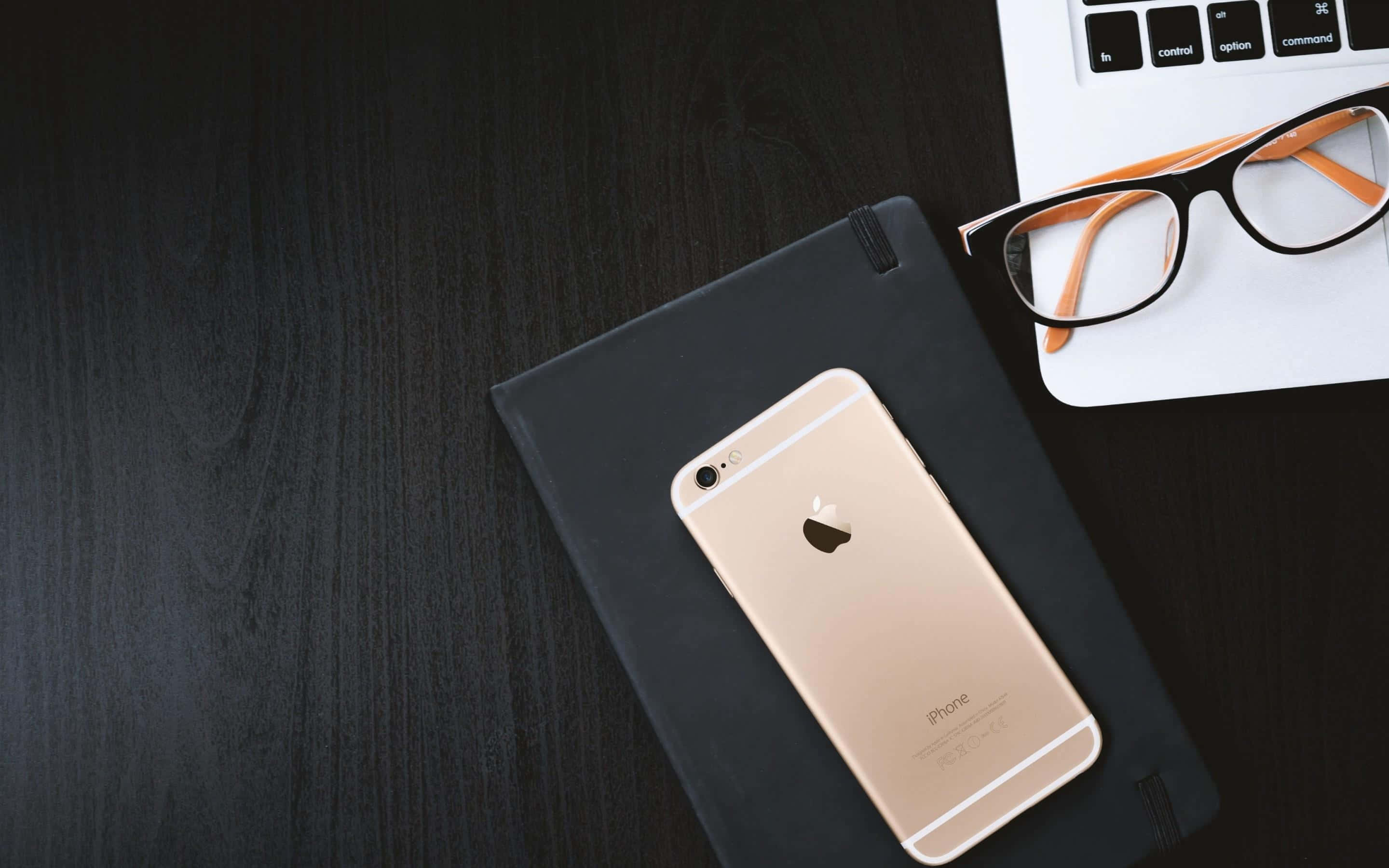 gold iPhone, black notebook, laptop, 2K Desktop Wallpaper
