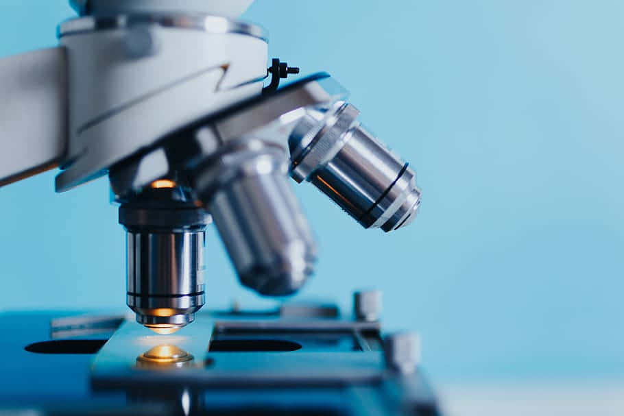 microscope, glowing stage light, soft blue background, SD Desktop Wallpaper