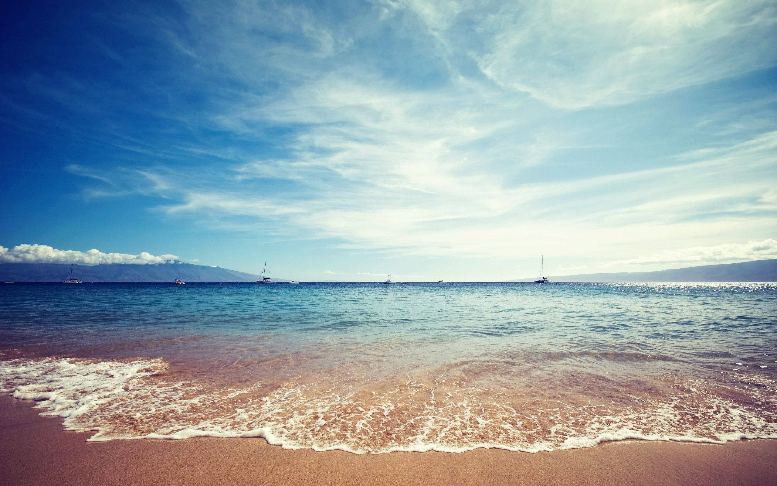 calm turquoise waves, pinkish sand beach, vast blue sky, 2K Desktop Wallpaper