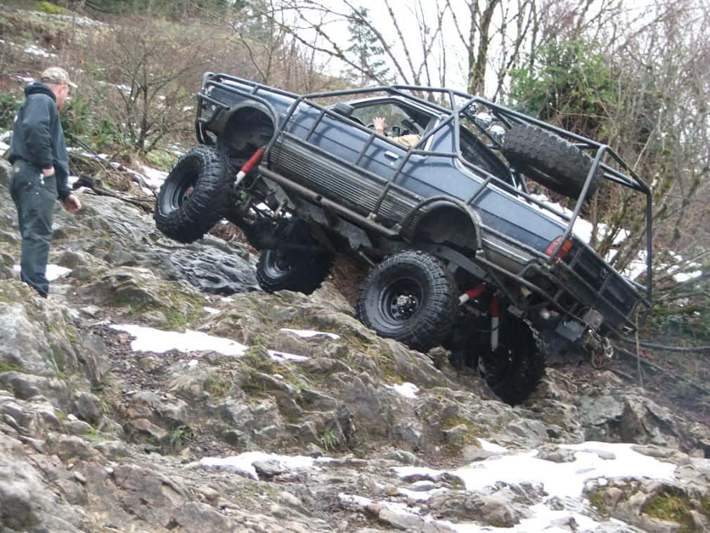 blue off-road truck, snowy rocky slope, man watches from below, SD Desktop Wallpaper