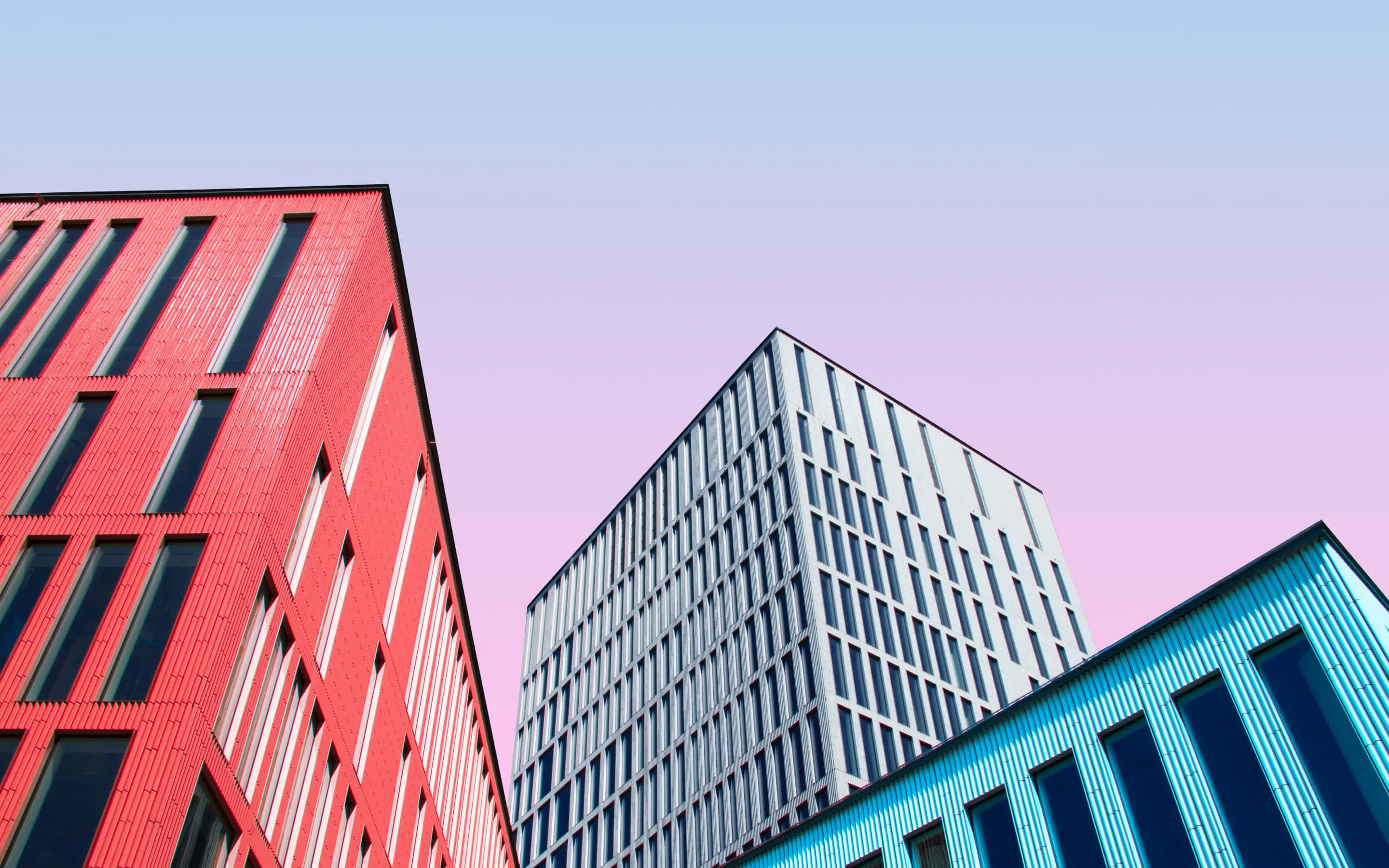 colorful modern office buildings skyline, vibrant red blue and silver, soft pink and blue gradient sky, 2K Desktop Wallpaper