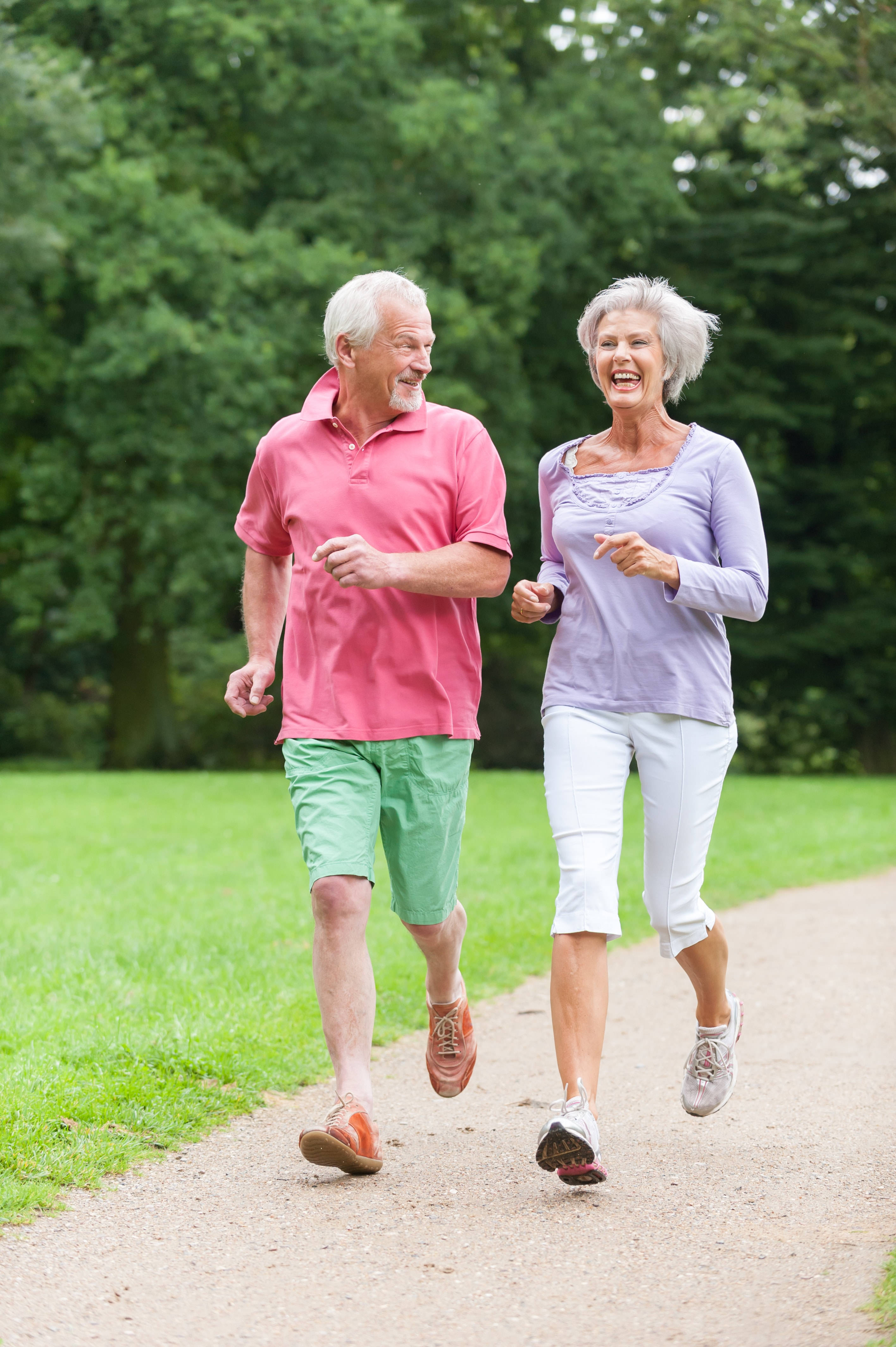 senior couple, sunlit park path, lush green trees, 4K Phone Wallpaper