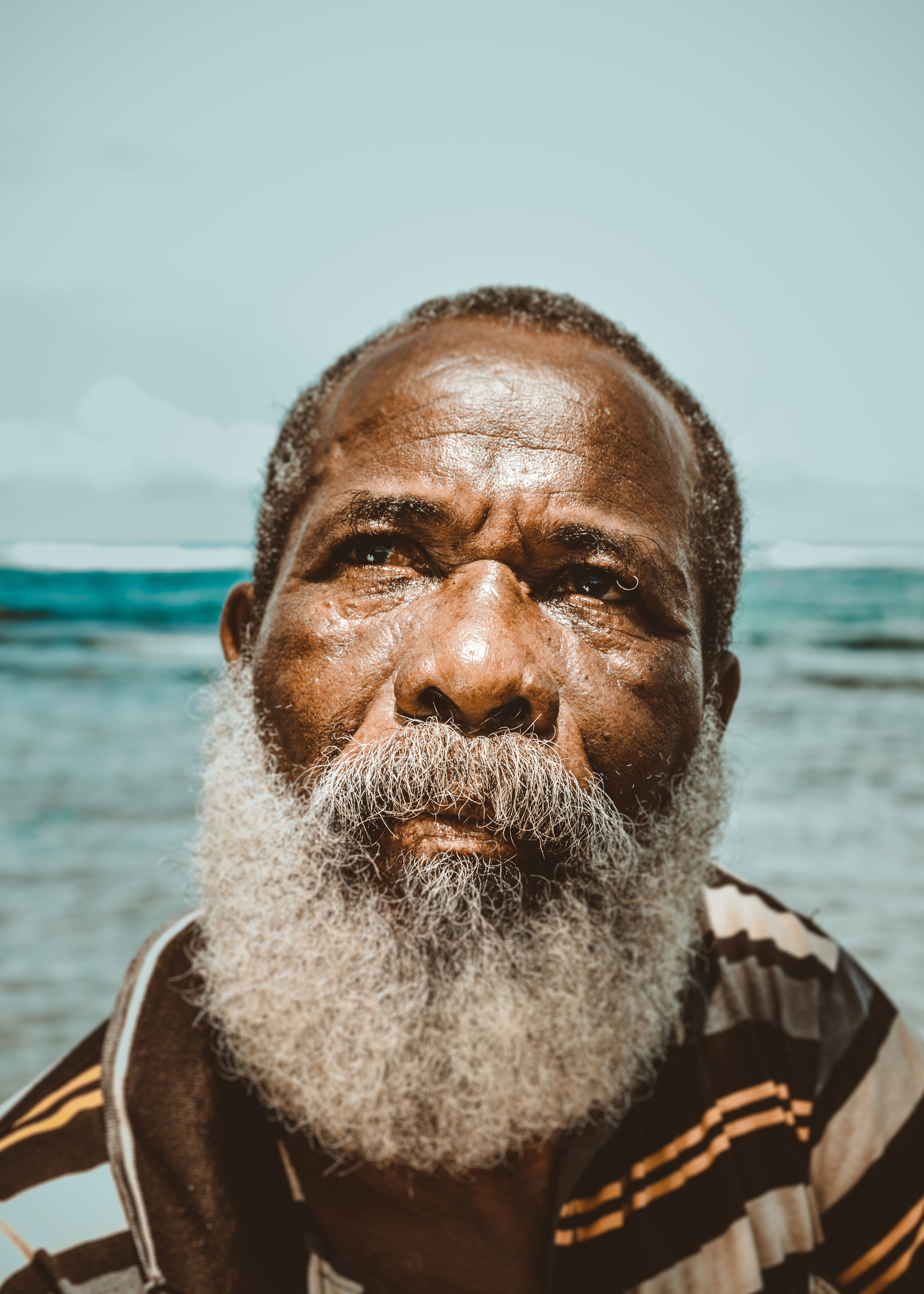 old black man, full white beard, turquoise ocean backdrop, 5K Phone Wallpaper
