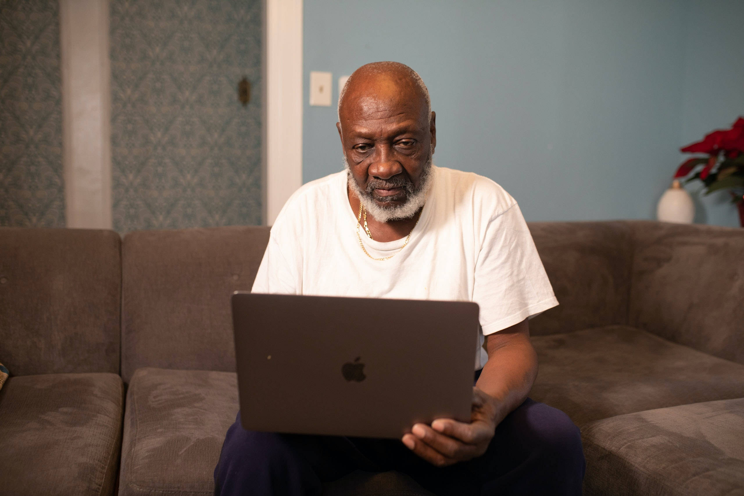 old black man, laptop, brown couch, 2K Desktop Wallpaper