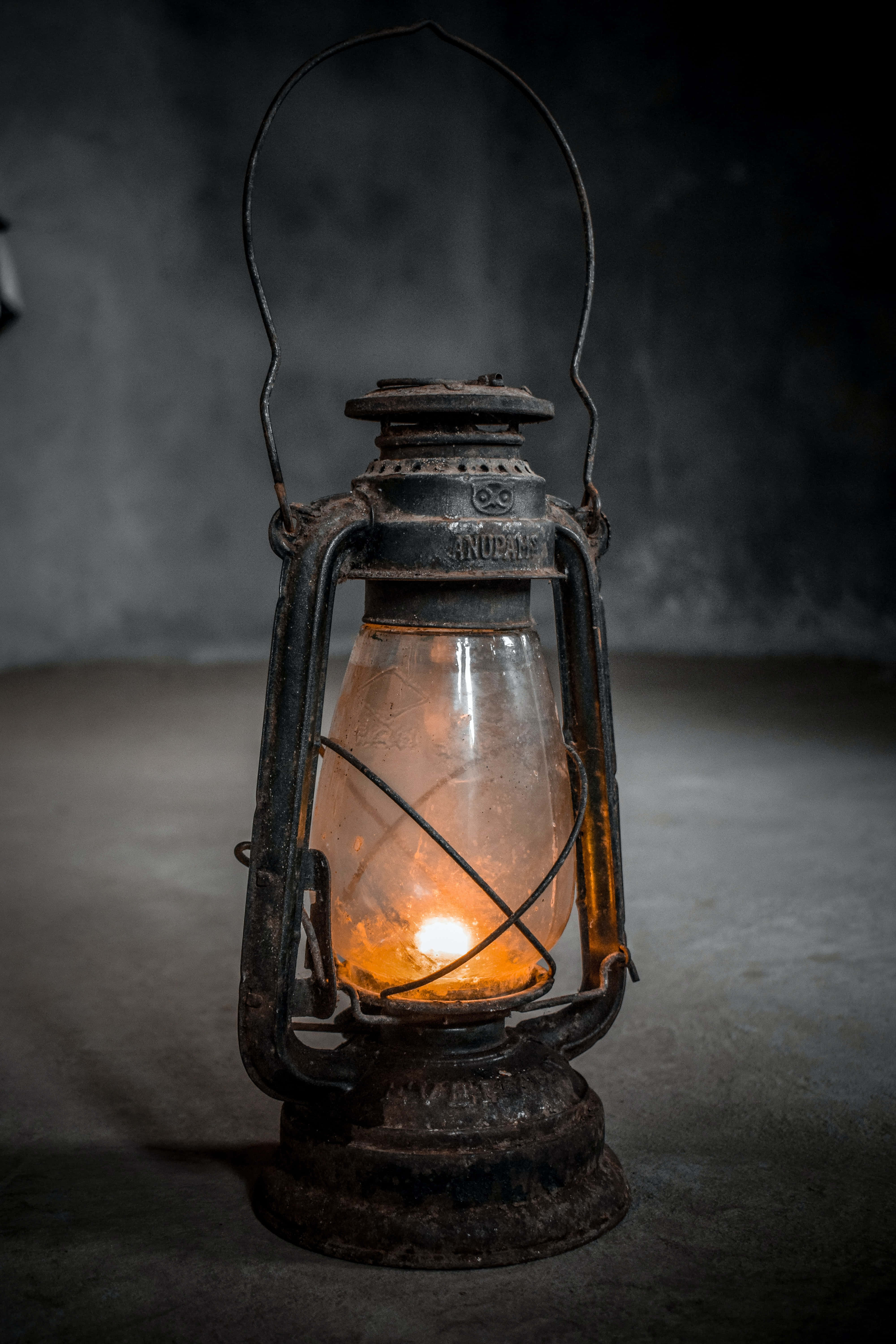 vintage oil lantern, warm glowing flame, dark textured wall, 5K Phone Wallpaper