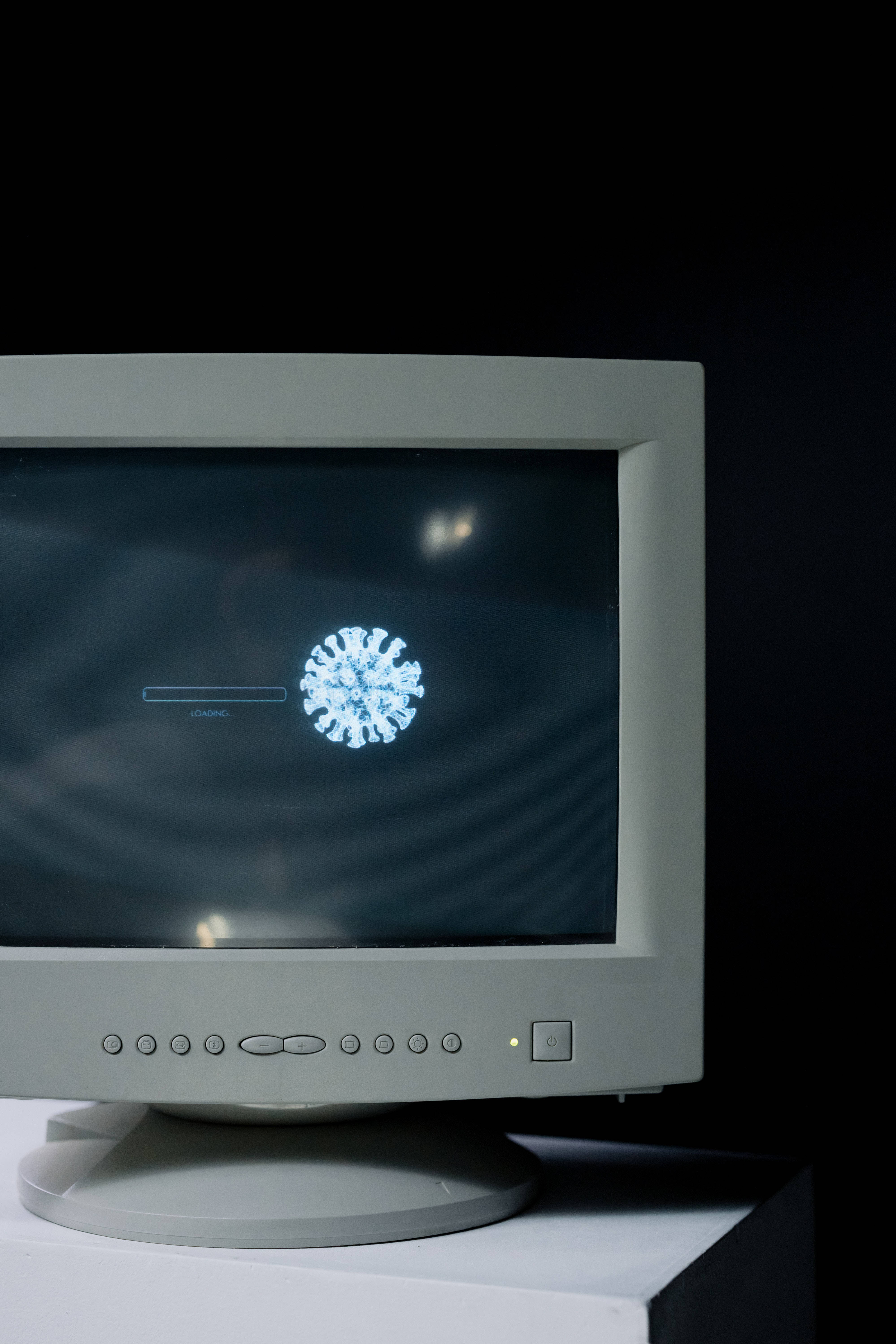 beige CRT monitor, glowing blue virus particle graphic, dark screen, 5K Phone Wallpaper