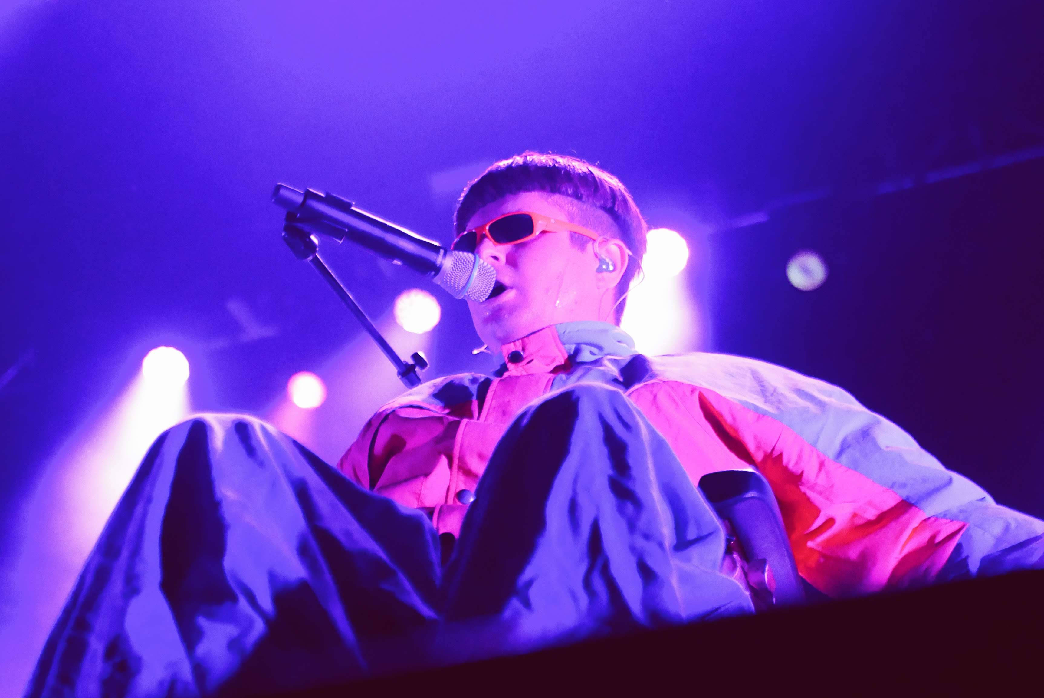 Oliver Tree, vibrant pink and blue outfit, purple stage lights, 2K Desktop Wallpaper