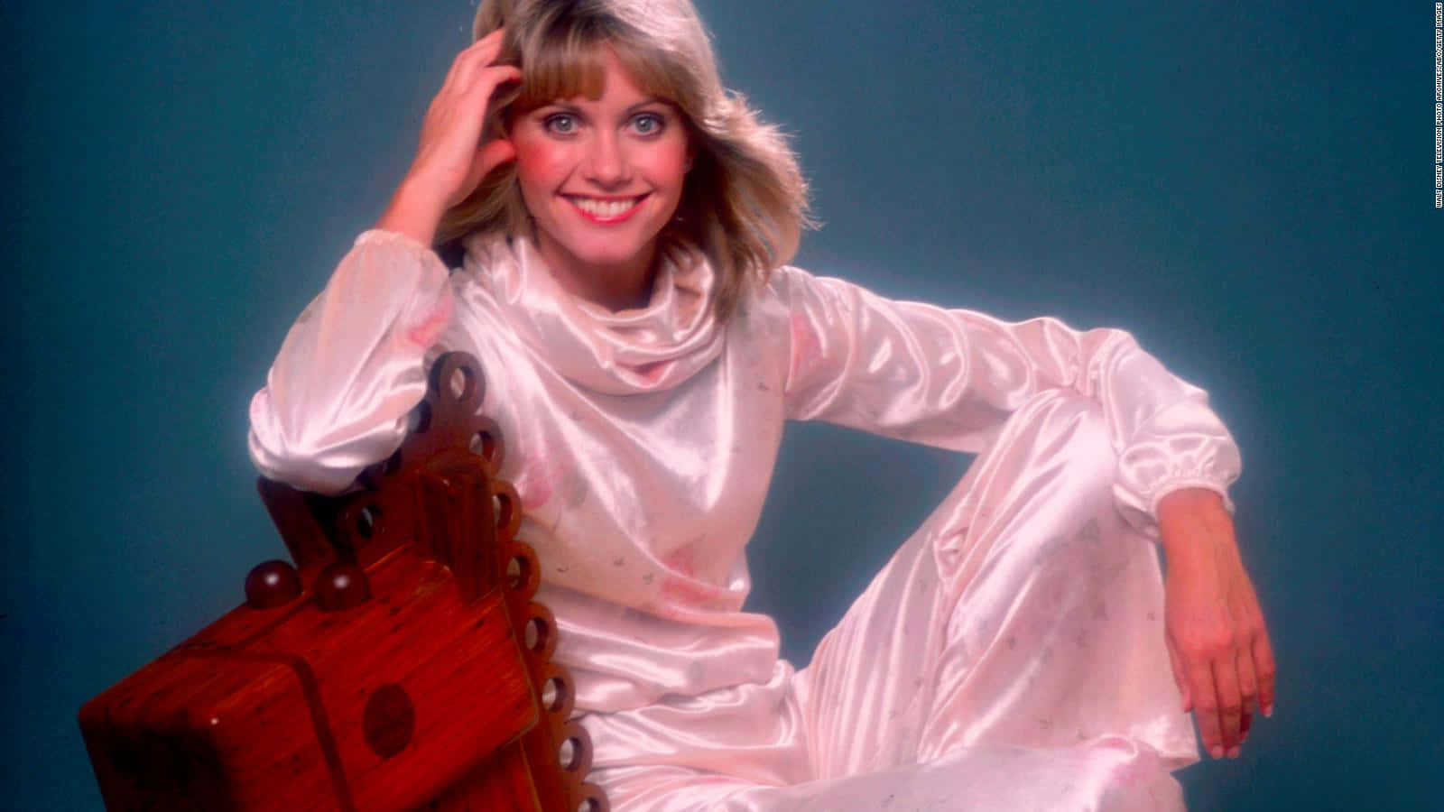 Olivia Newton John, shiny pink satin outfit, teal studio backdrop, HD Desktop Wallpaper