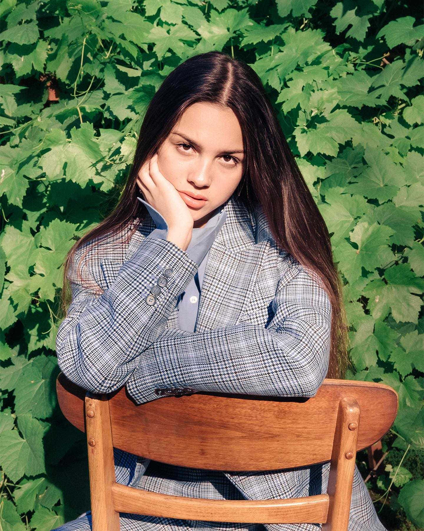 Olivia Rodrigo, long dark hair, wooden chair, HD Phone Wallpaper