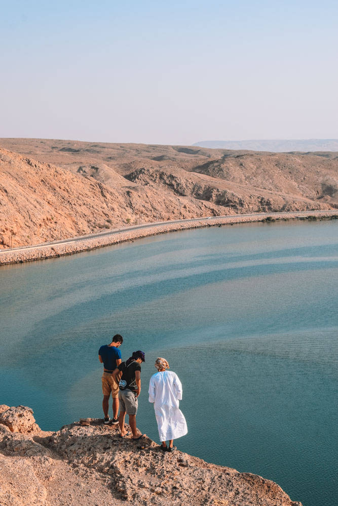 Oman, three men, rocky cliff, SD Phone Wallpaper