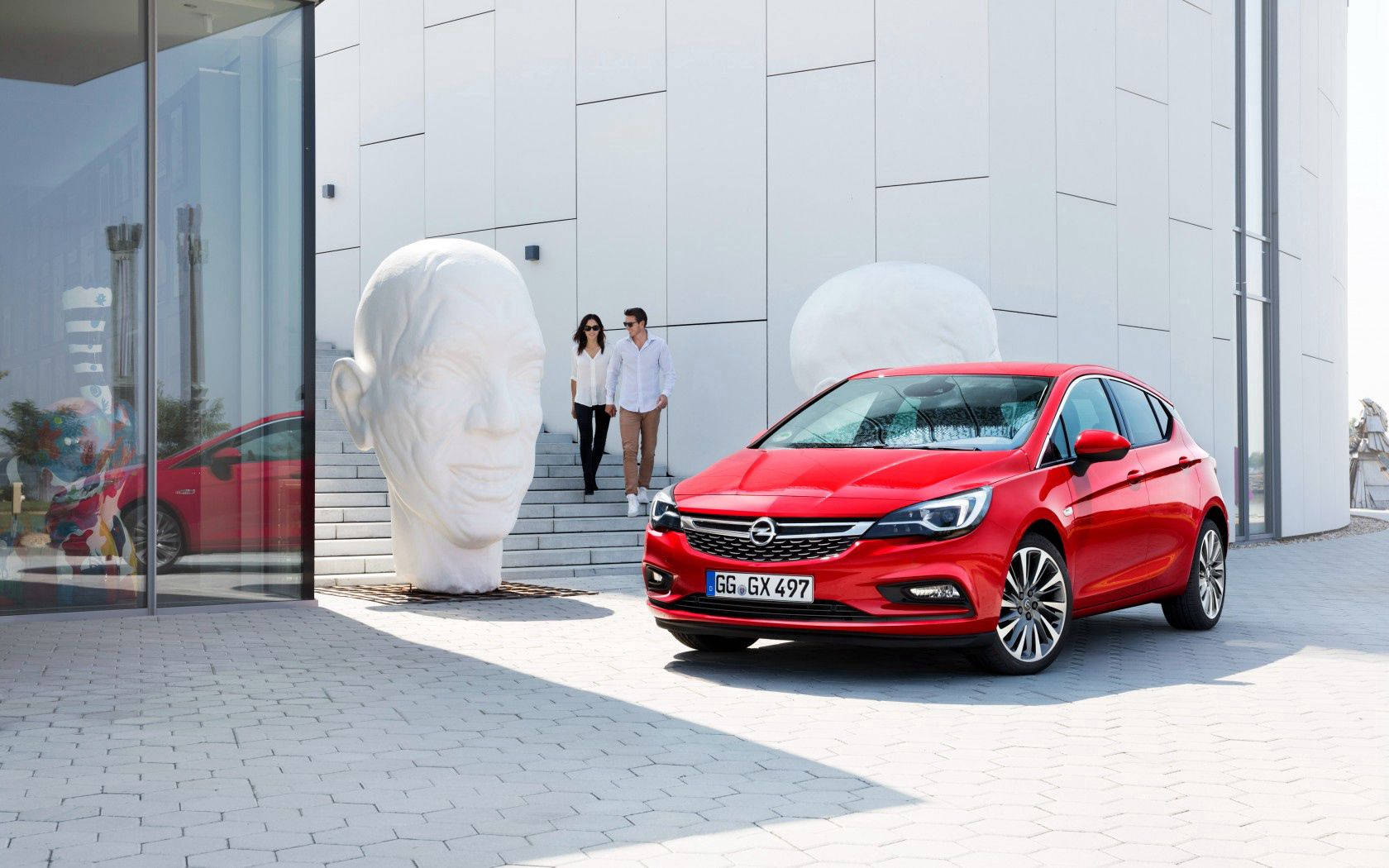 Red Opel Astra, modern building, giant white head sculptures, HD Desktop Wallpaper