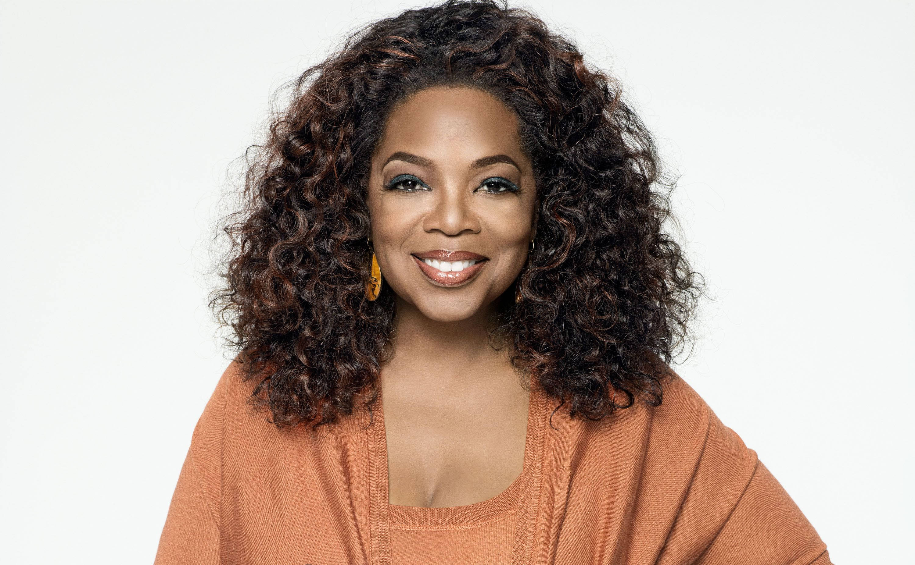 Oprah Winfrey, voluminous curly hair, soft orange cardigan, 2K Desktop Wallpaper
