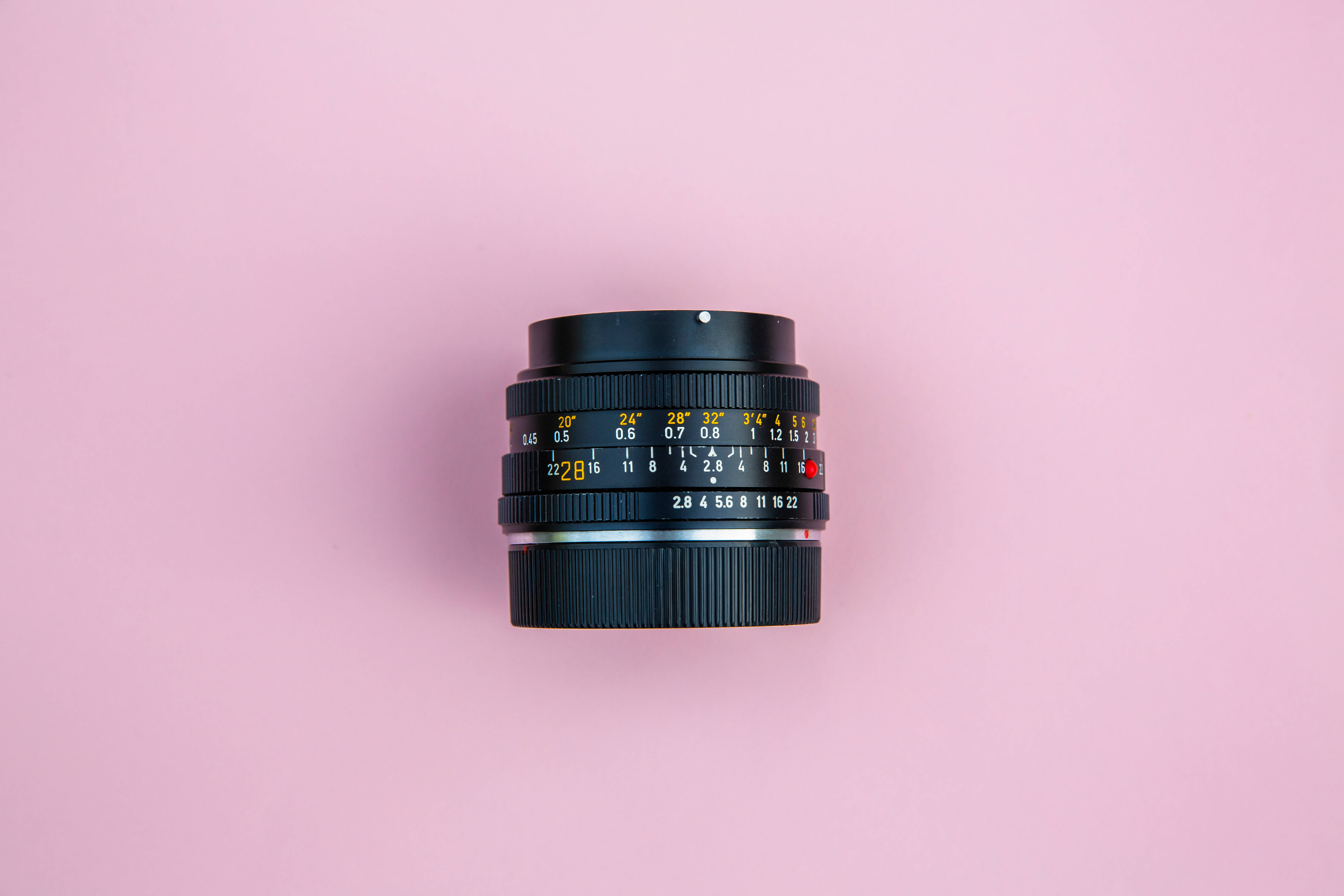 pastel photography lens, yellow and red markings, soft pink background, 5K Desktop Wallpaper