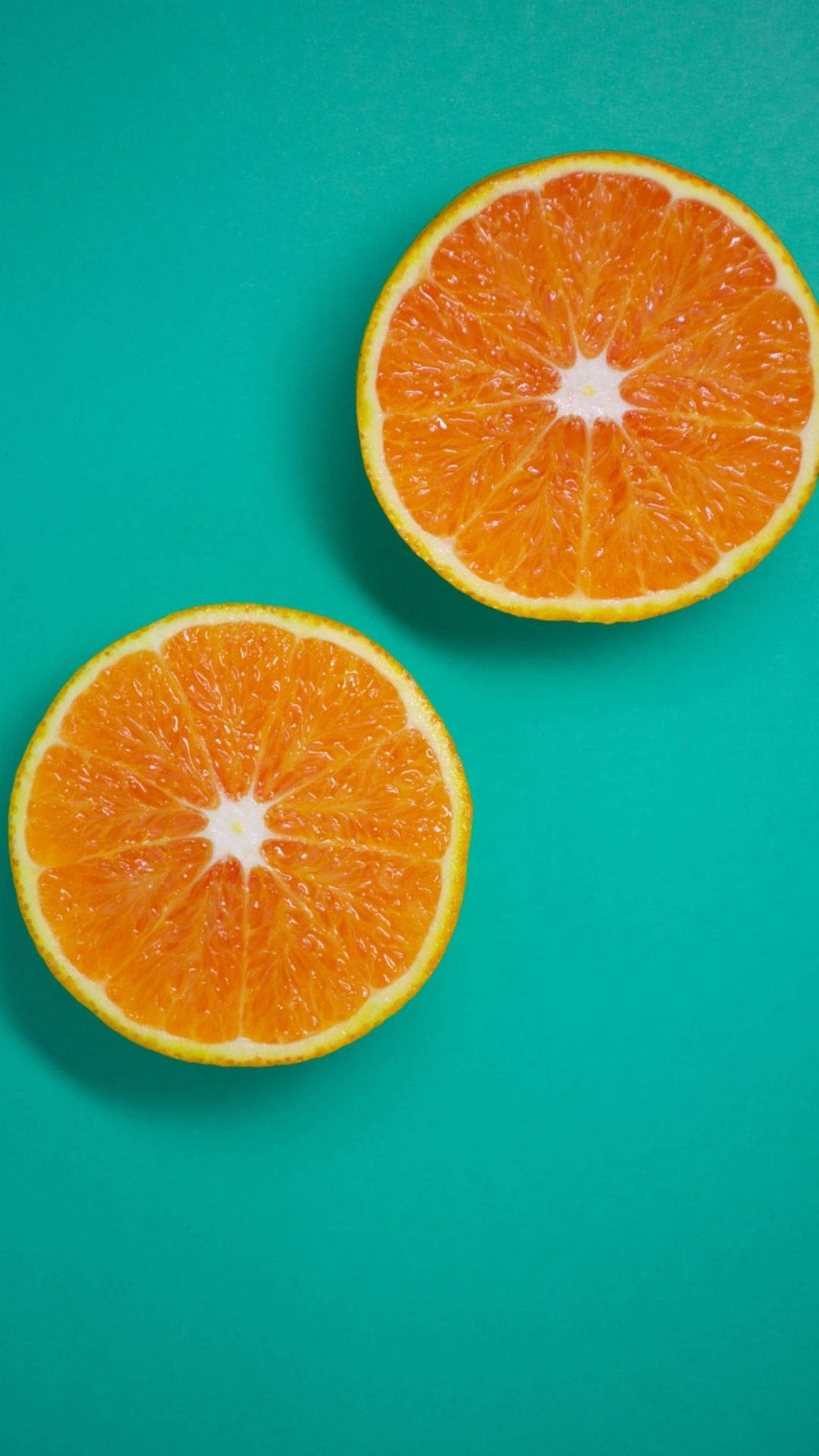 three sliced orange fruits, vibrant orange halves, teal background, Full HD Phone Wallpaper
