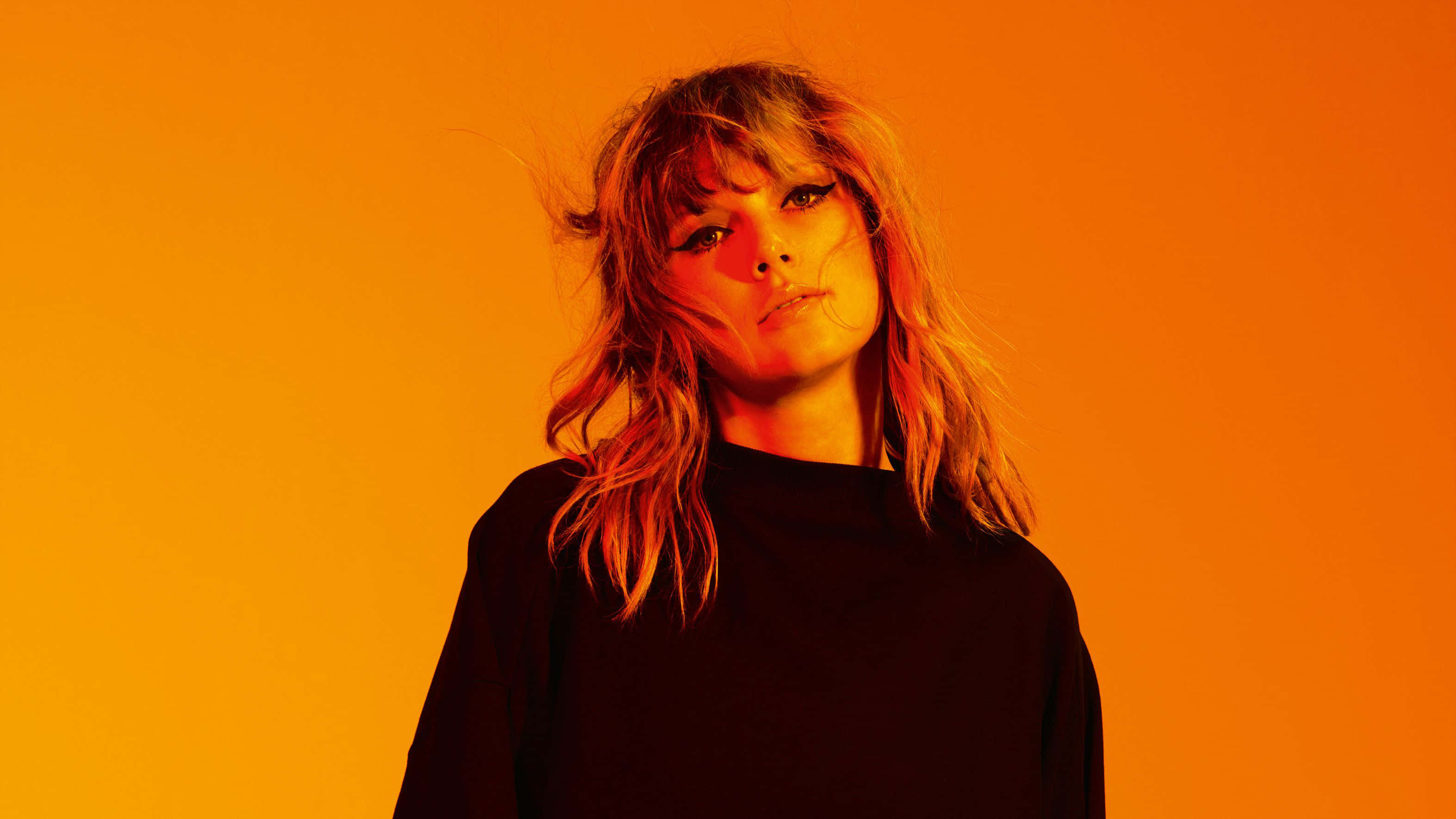 Orange Hued Portrait, vibrant orange gradient background, tousled hair, 2K Desktop Wallpaper