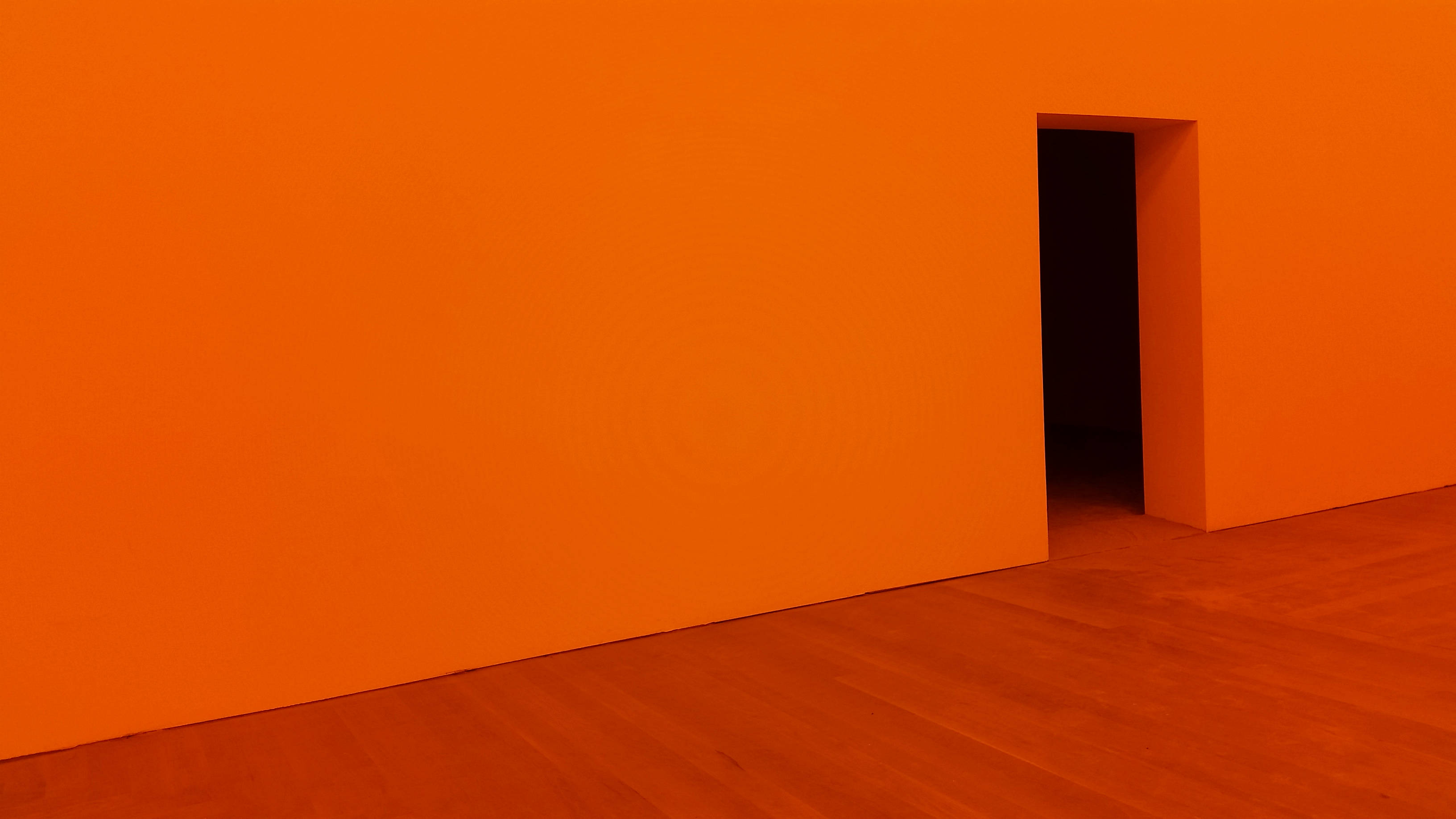 minimalist room, vibrant orange walls, wooden floor, 2K Desktop Wallpaper