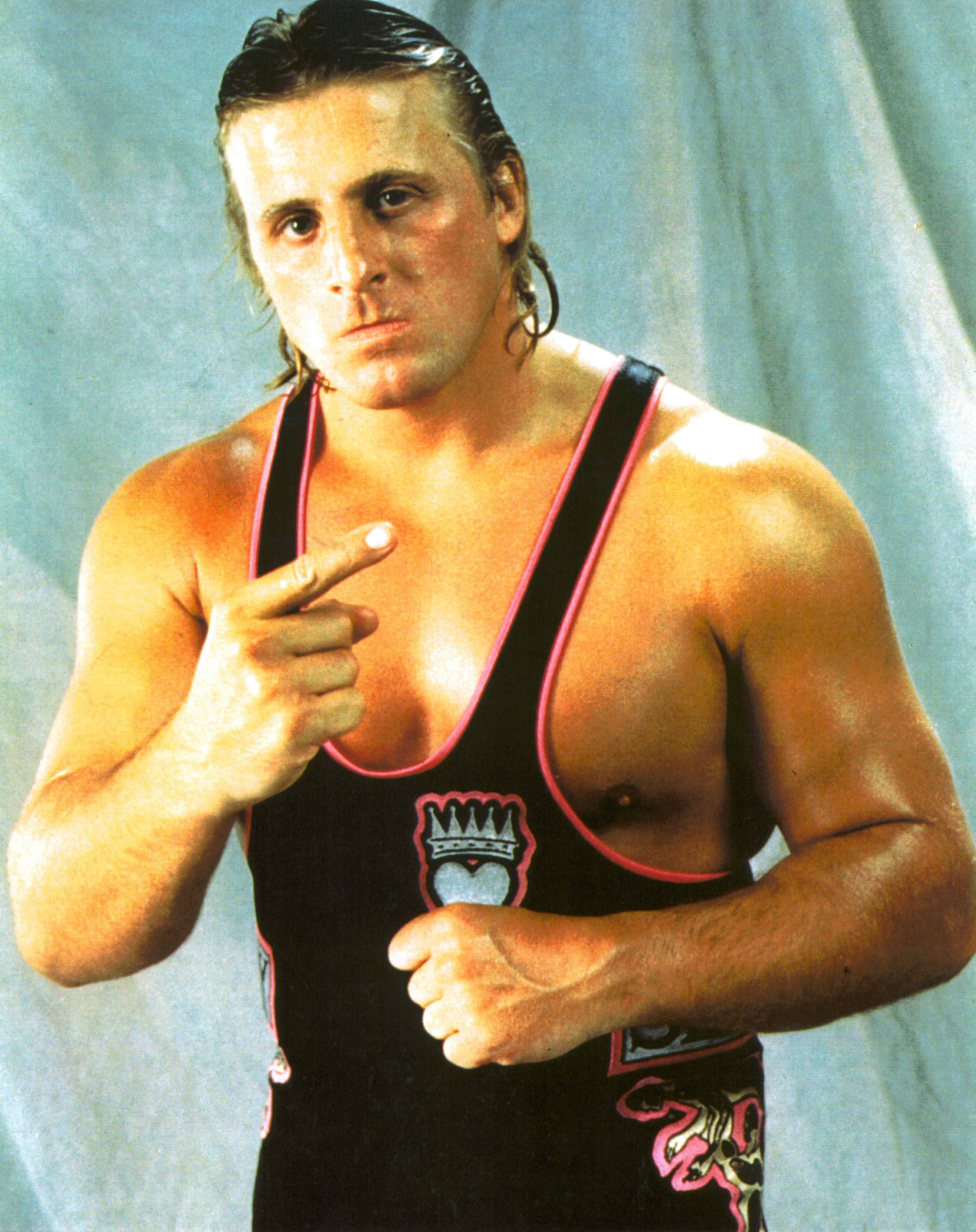 Owen Hart, black and pink singlet, blue backdrop, 2K Phone Wallpaper