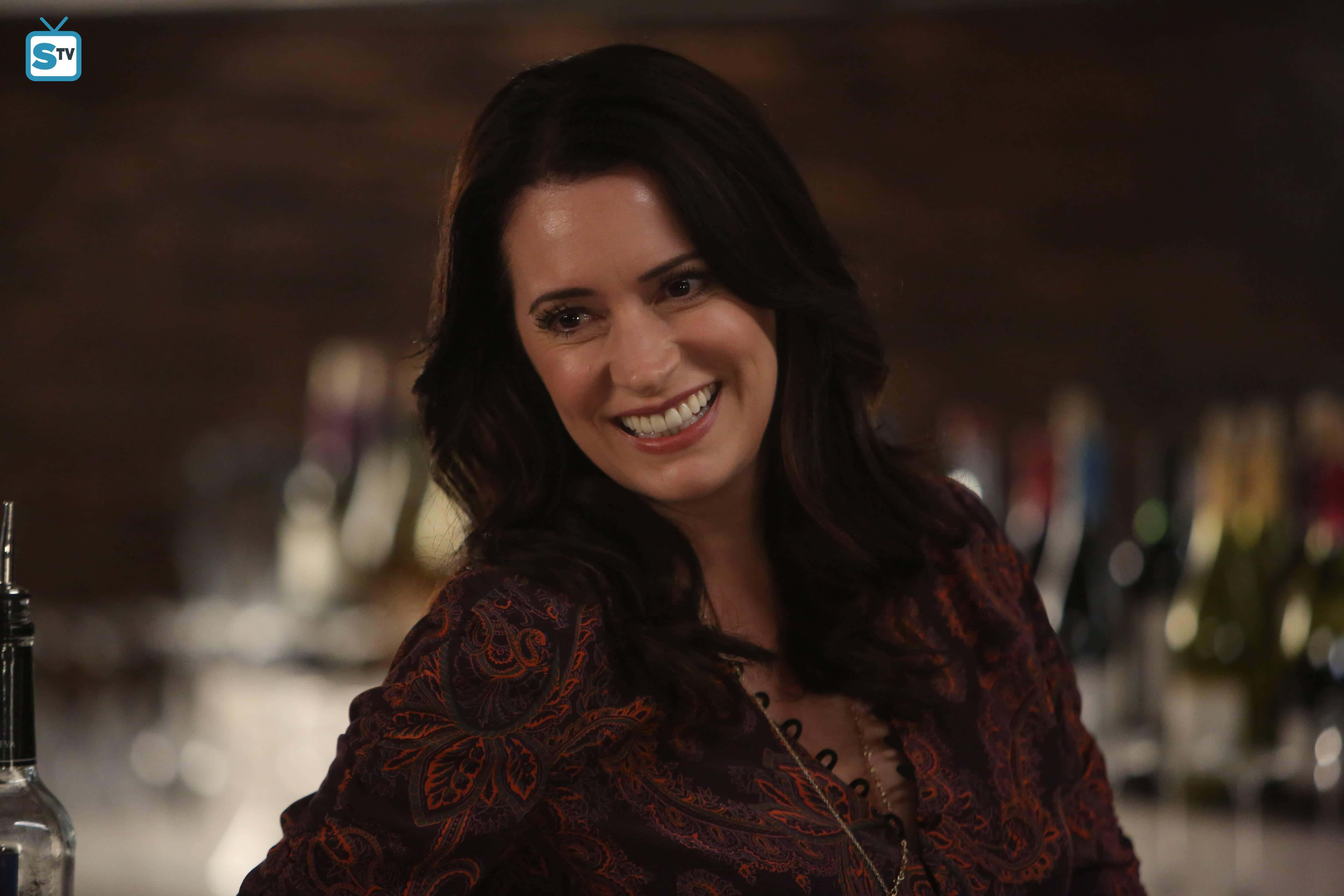 Paget Brewster, dimly lit bar, blurred bottles, 5K Desktop Wallpaper