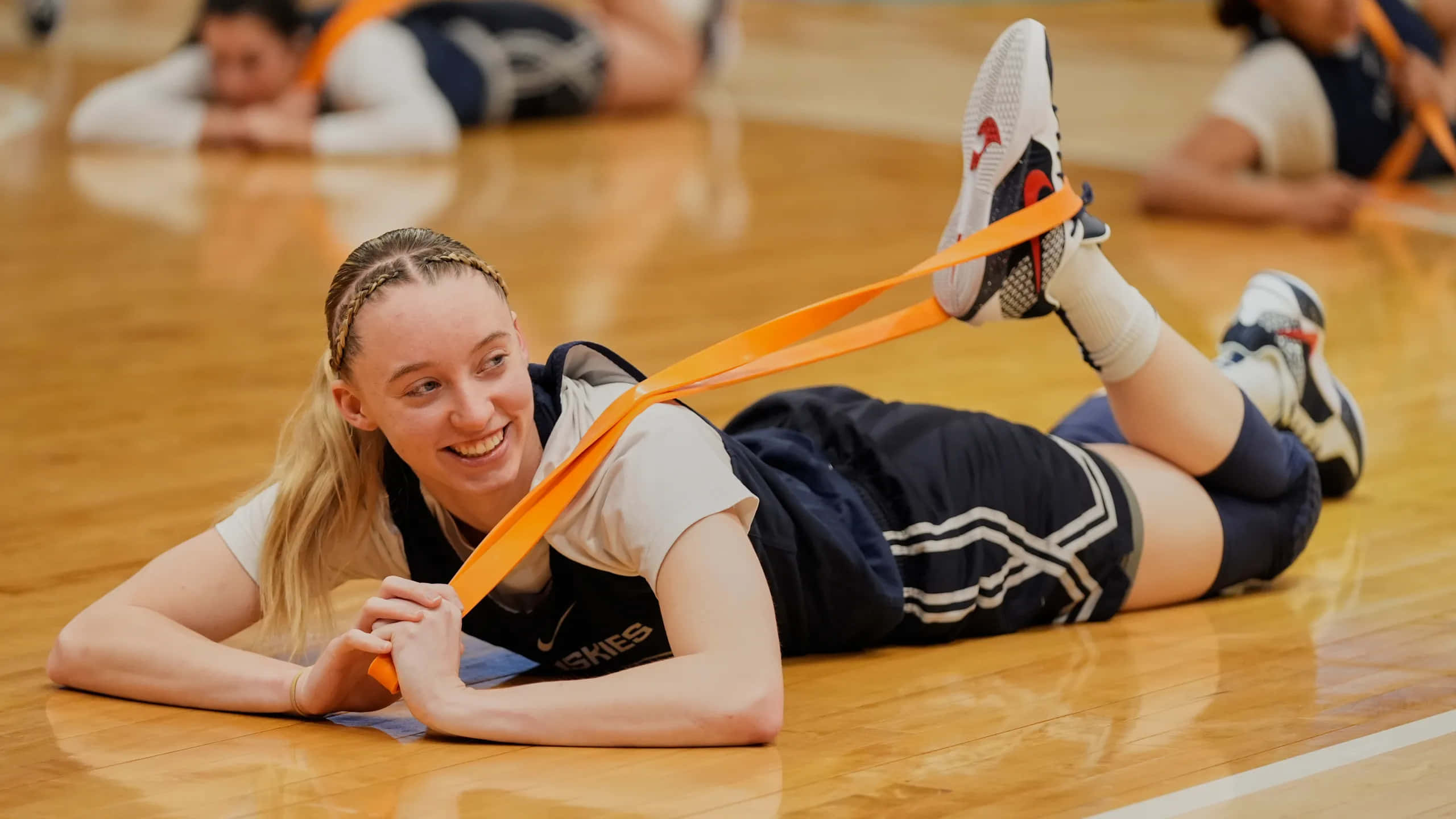 Paige Bueckers, polished wooden court, orange resistance band, 2K Desktop Wallpaper