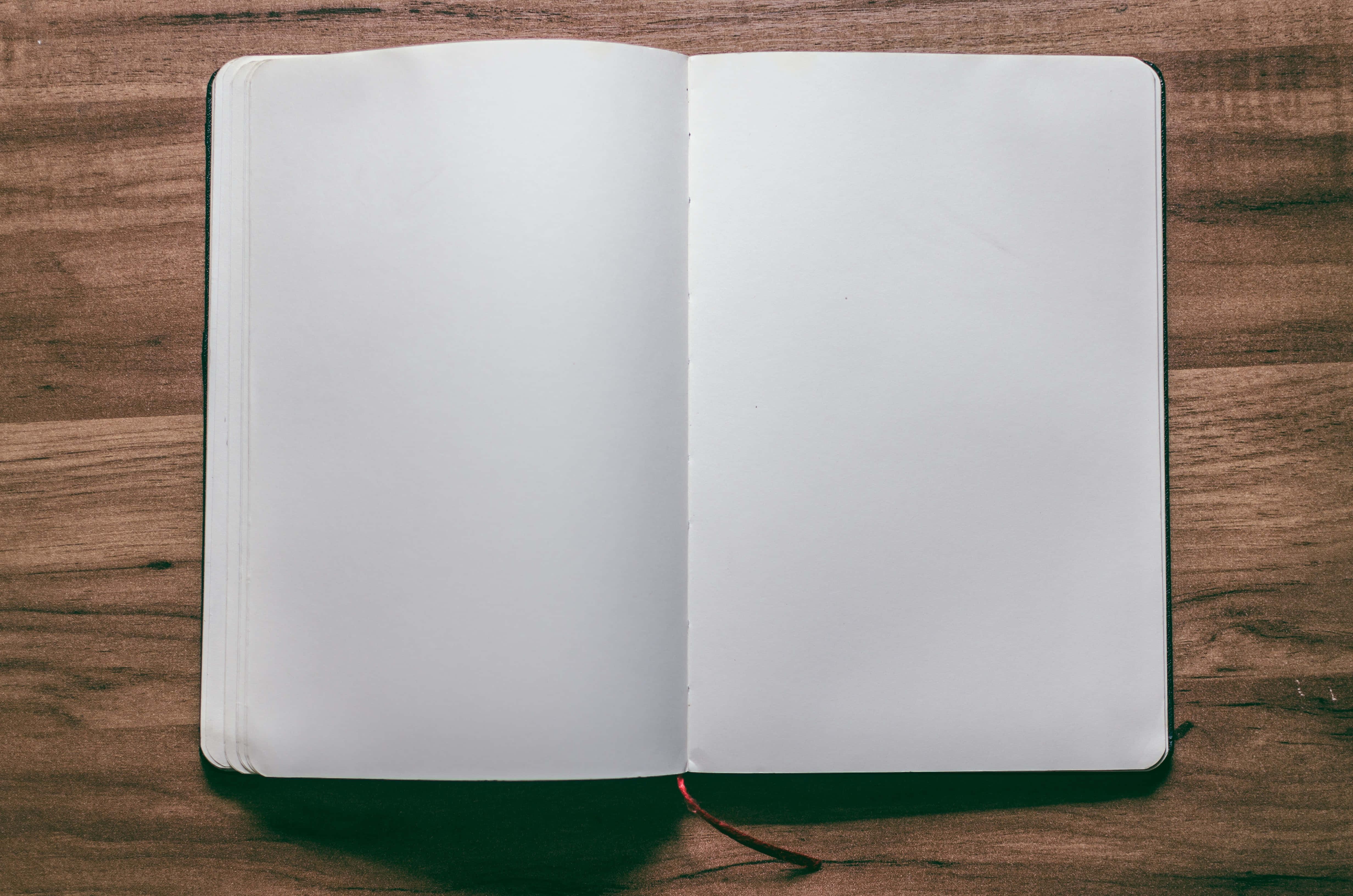 empty notepad paper, crisp white pages, warm wooden surface, 4K Desktop Wallpaper