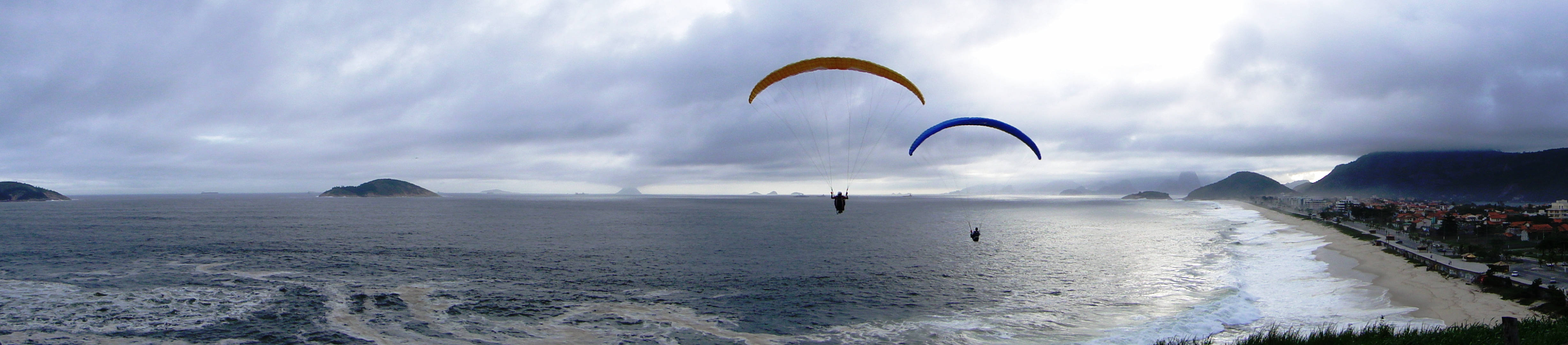 paragliding pilots, vast ocean, cloudy skies, 4K Desktop Wallpaper
