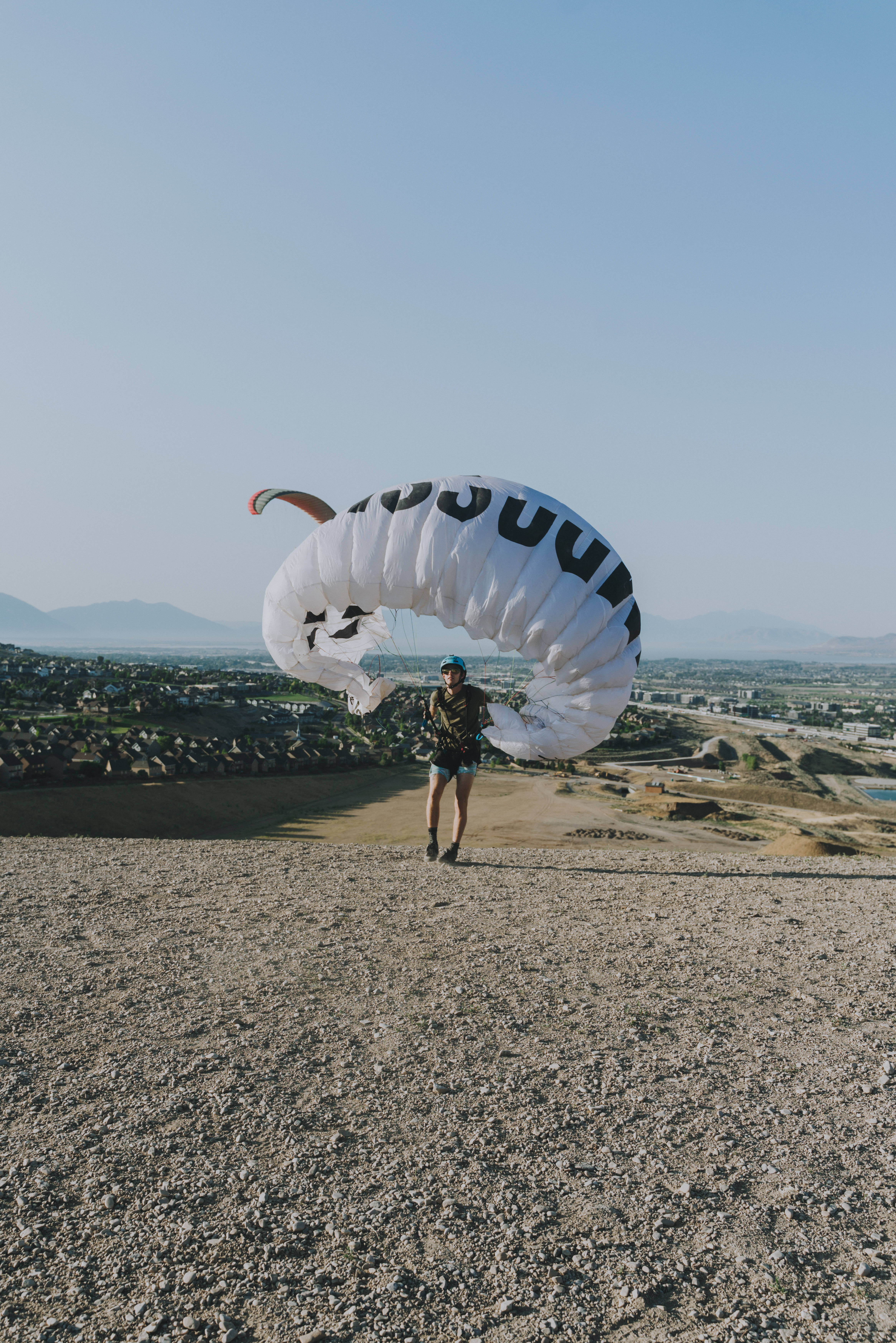 paragliding, gravel hilltop, large white paraglider, 5K Phone Wallpaper