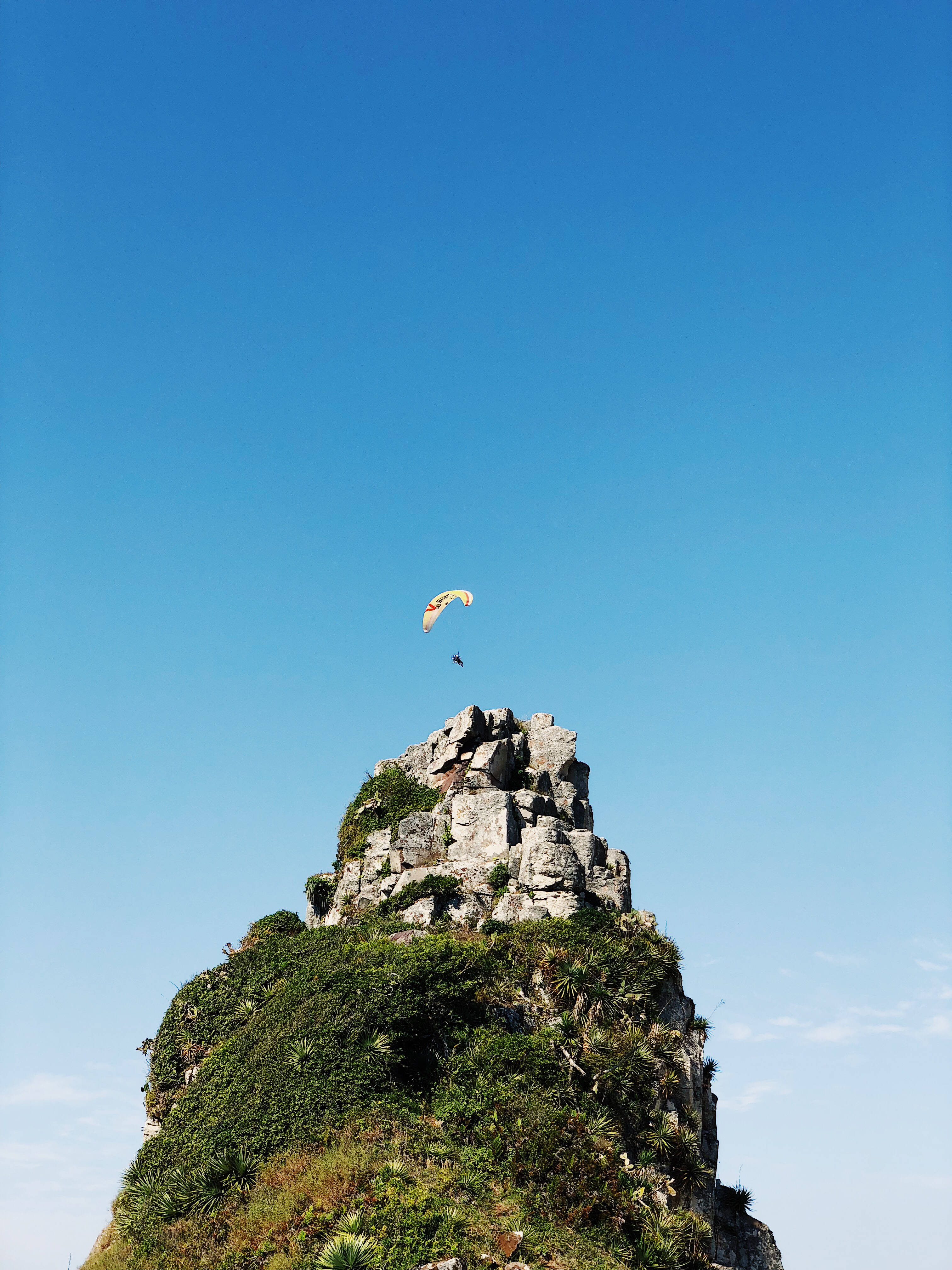 paragliding, pointed rock cliff, rugged green cliff, 4K Phone Wallpaper