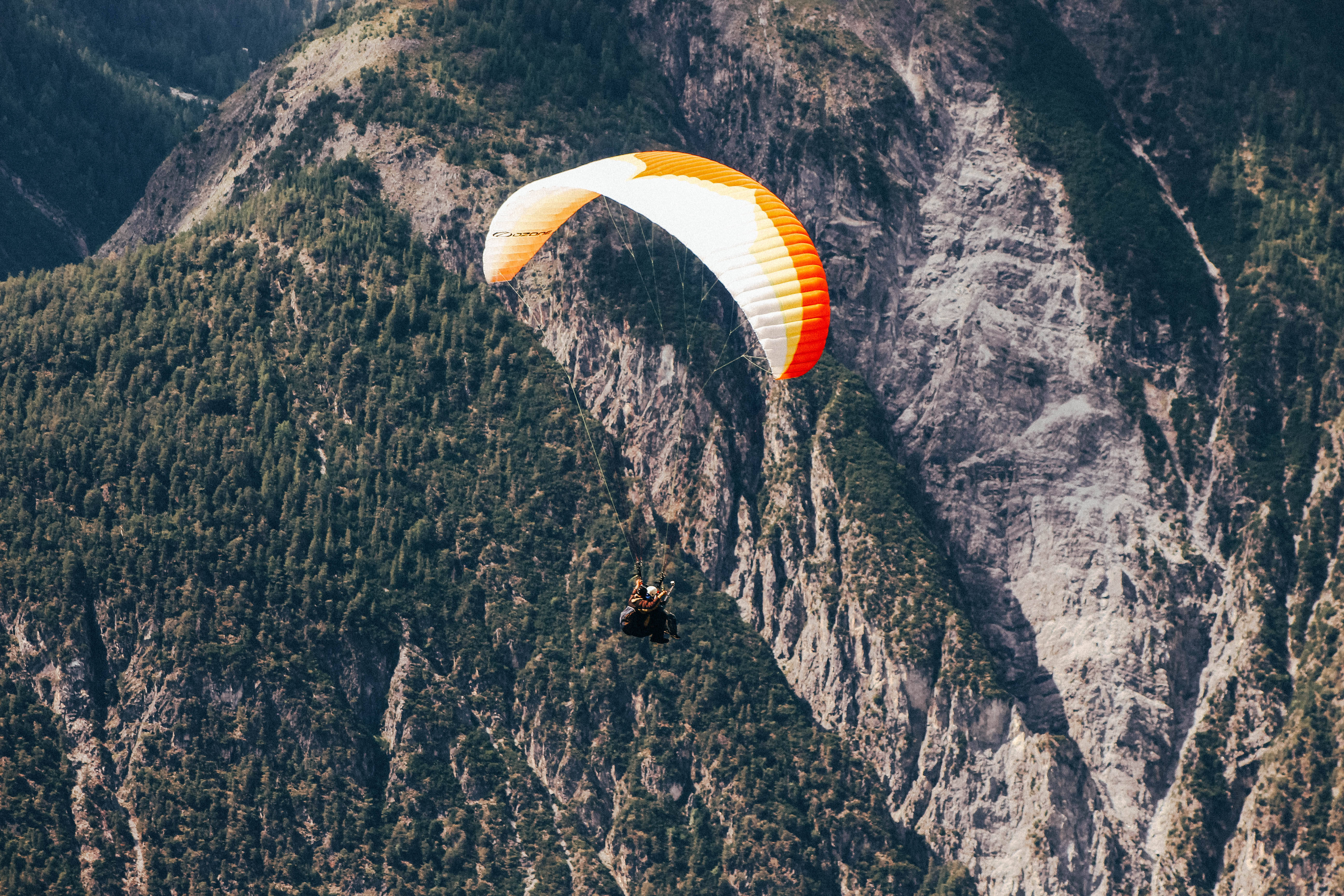 paragliding, orange and white canopy, rugged mountain range, 5K Desktop Wallpaper