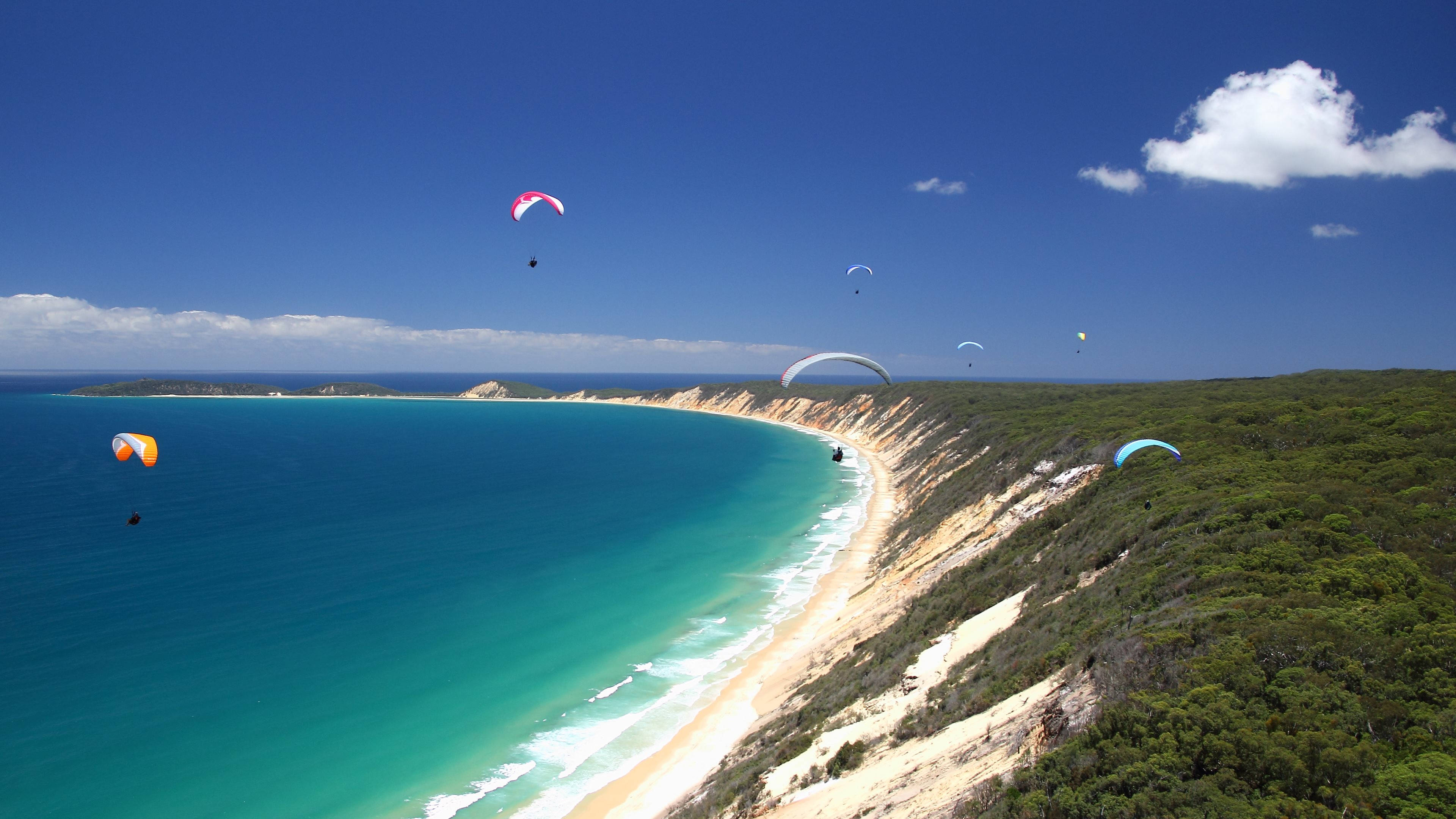 colossal slanted cliff, vibrant turquoise waters, sandy beach, 4K Desktop Wallpaper