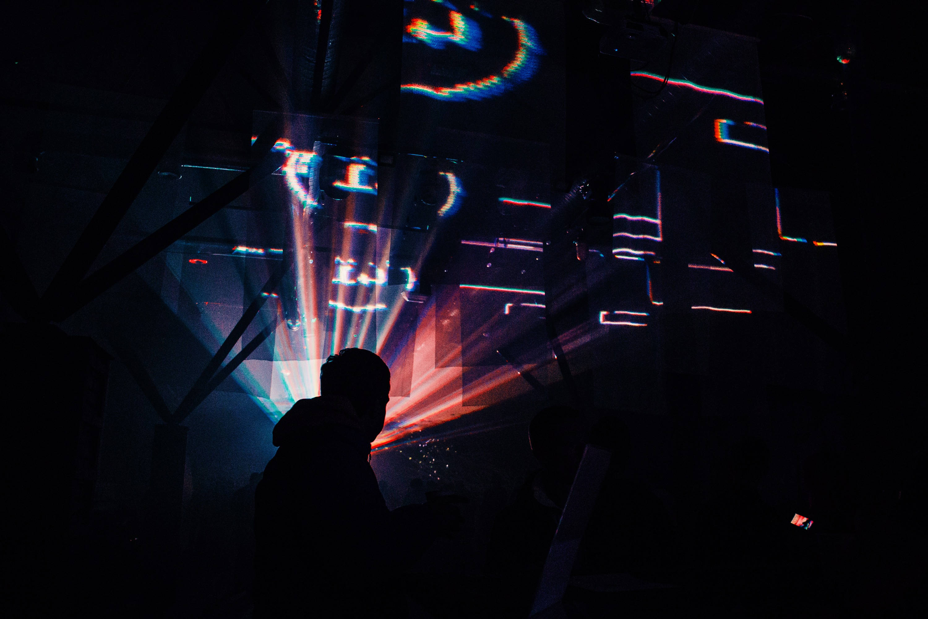 futuristic club, vibrant digital light projections, dark geometric wall, 2K Desktop Wallpaper