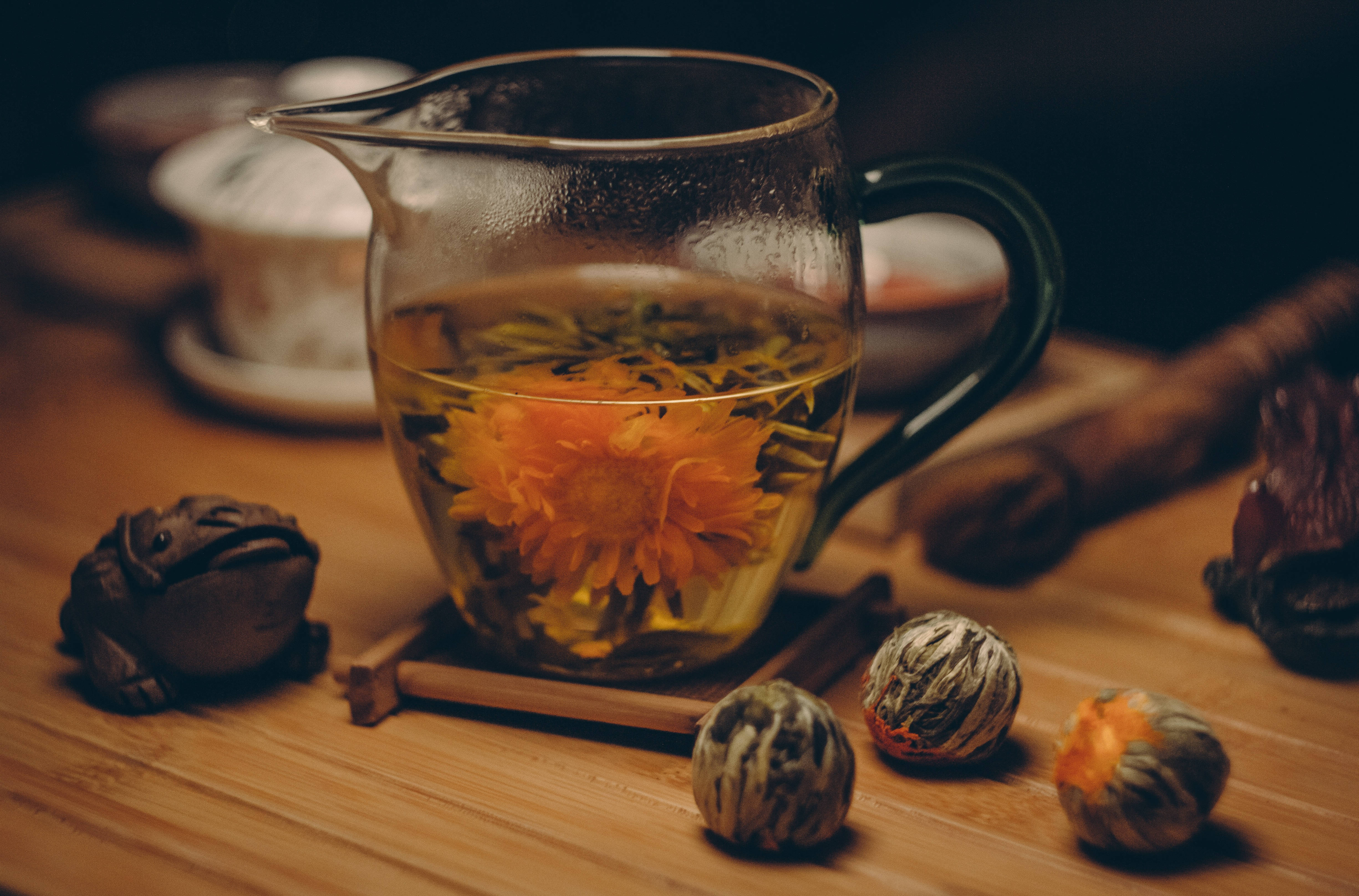 blooming orange chrysanthemum tea flower, glass teapot, warm wooden table, 4K Desktop Wallpaper