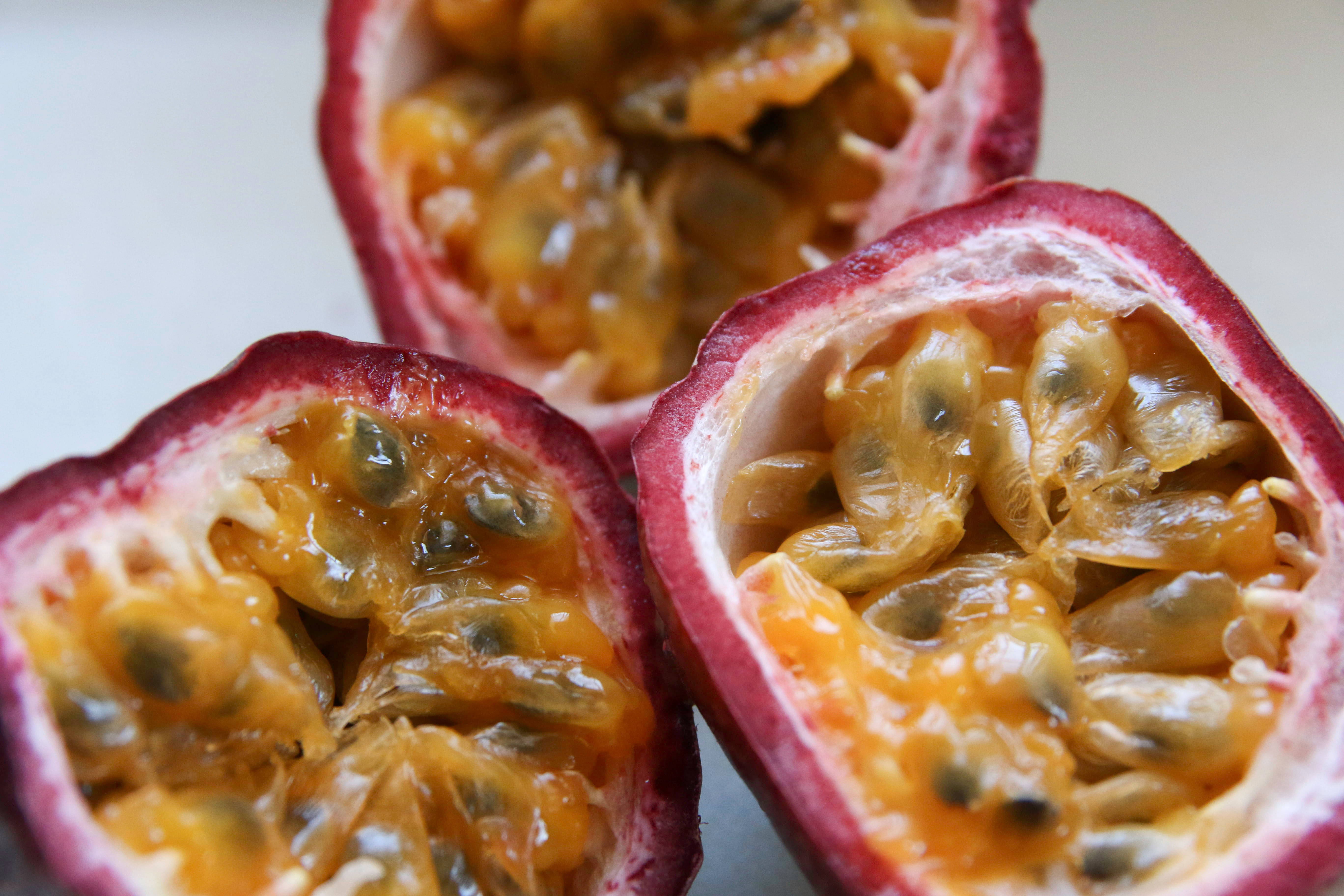 sliced ripe passion fruit, glistening golden pulp, dark seeds, 5K Desktop Wallpaper