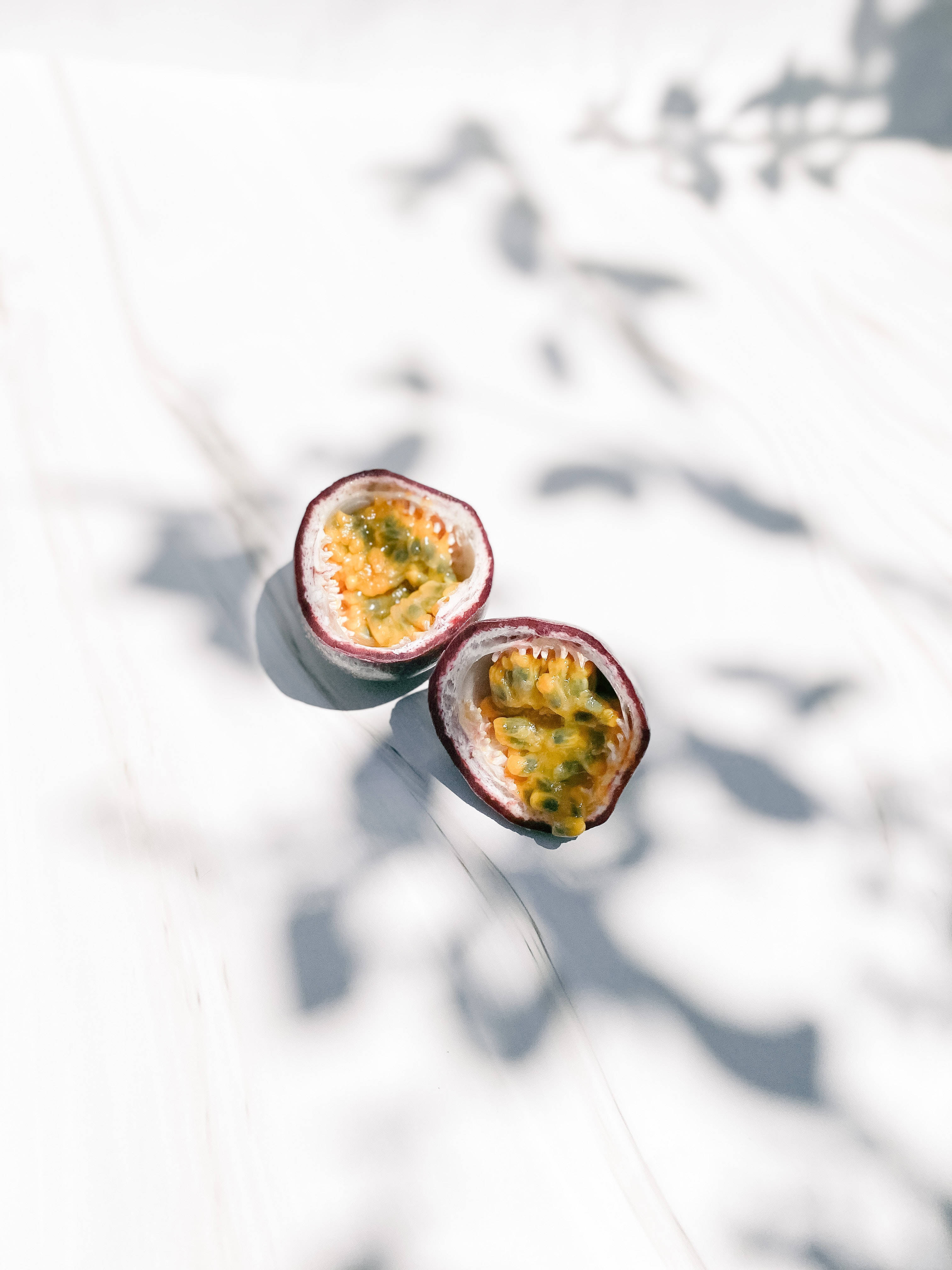 passion fruit, white surface, sunlight, 4K Phone Wallpaper