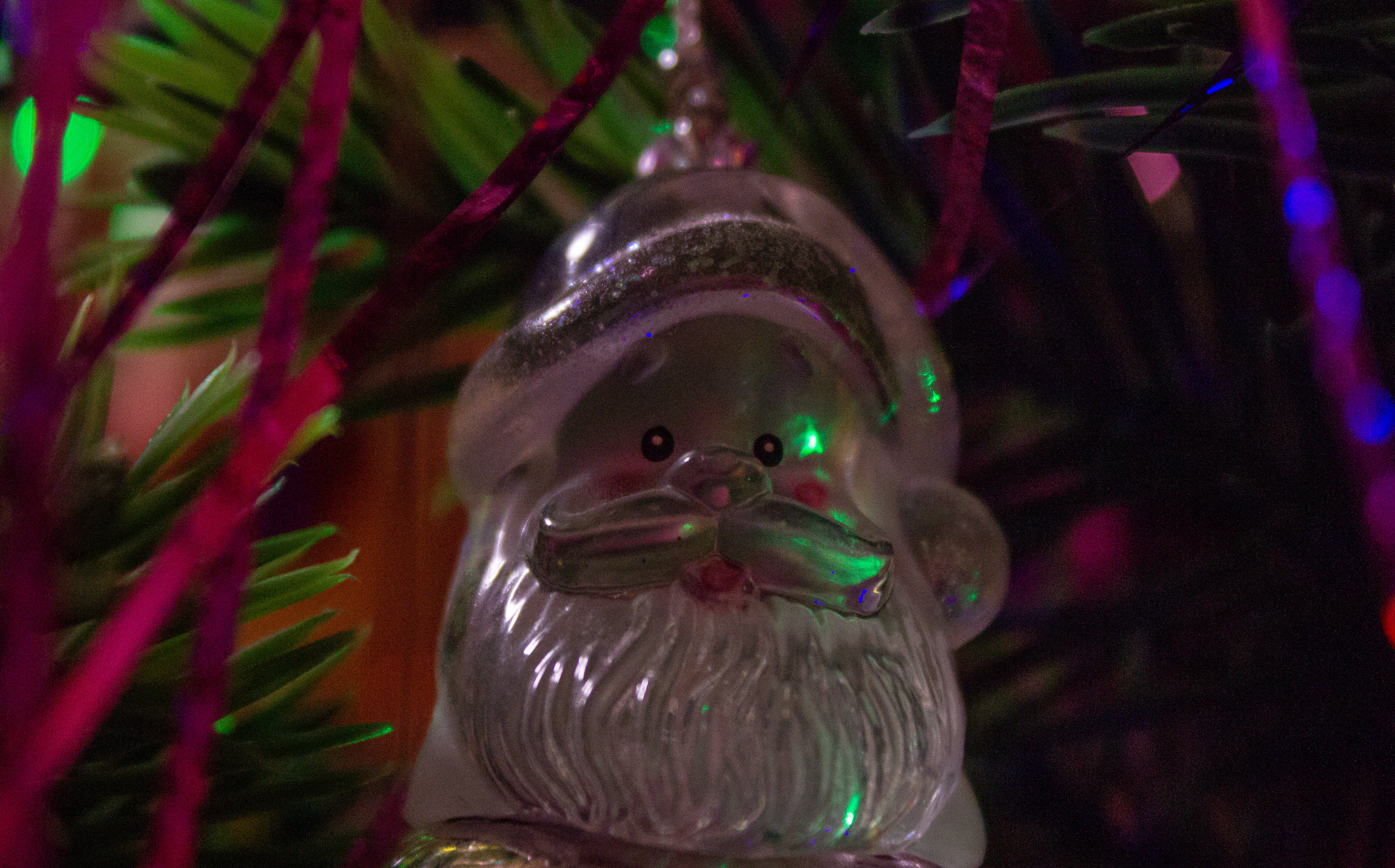 glittery glass Santa Claus ornament, green pine needles, colorful tinsel, 4K Desktop Wallpaper