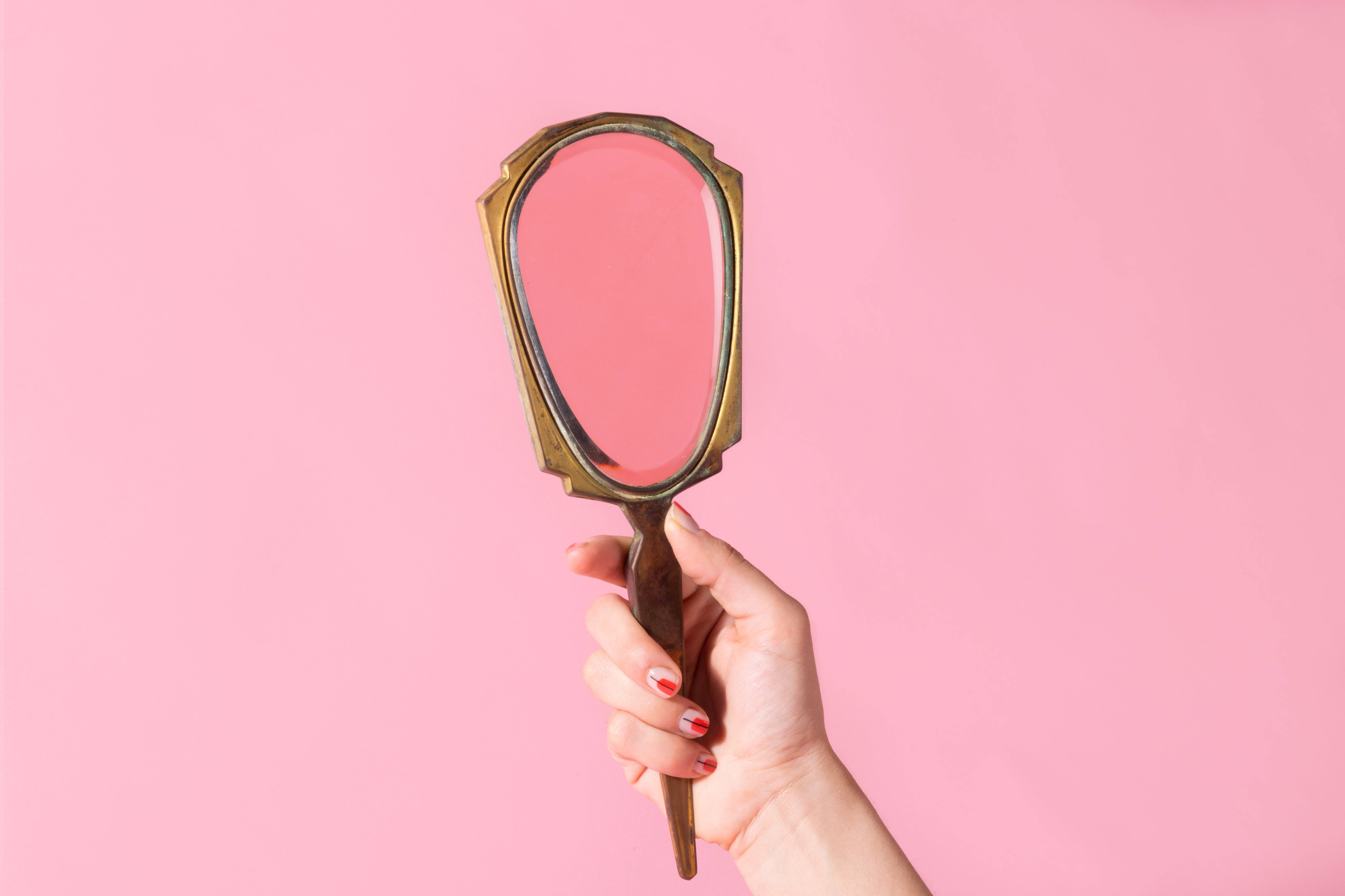 pastel pink color background, ornate brass-handled hand mirror, red and white nail polish, 5K Desktop Wallpaper