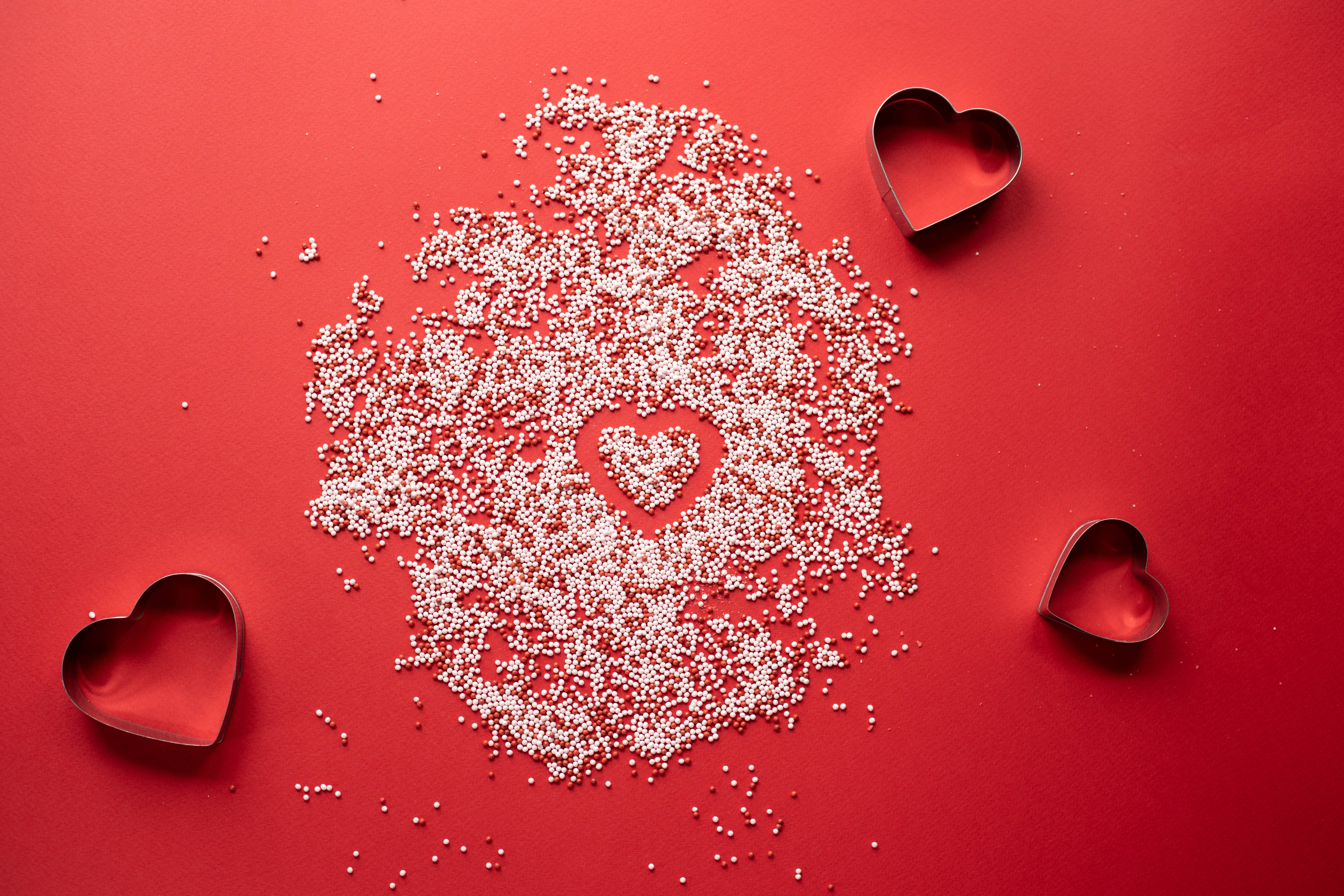 pastel pink heart, white sugar pearls, vibrant red surface, 5K Desktop Wallpaper