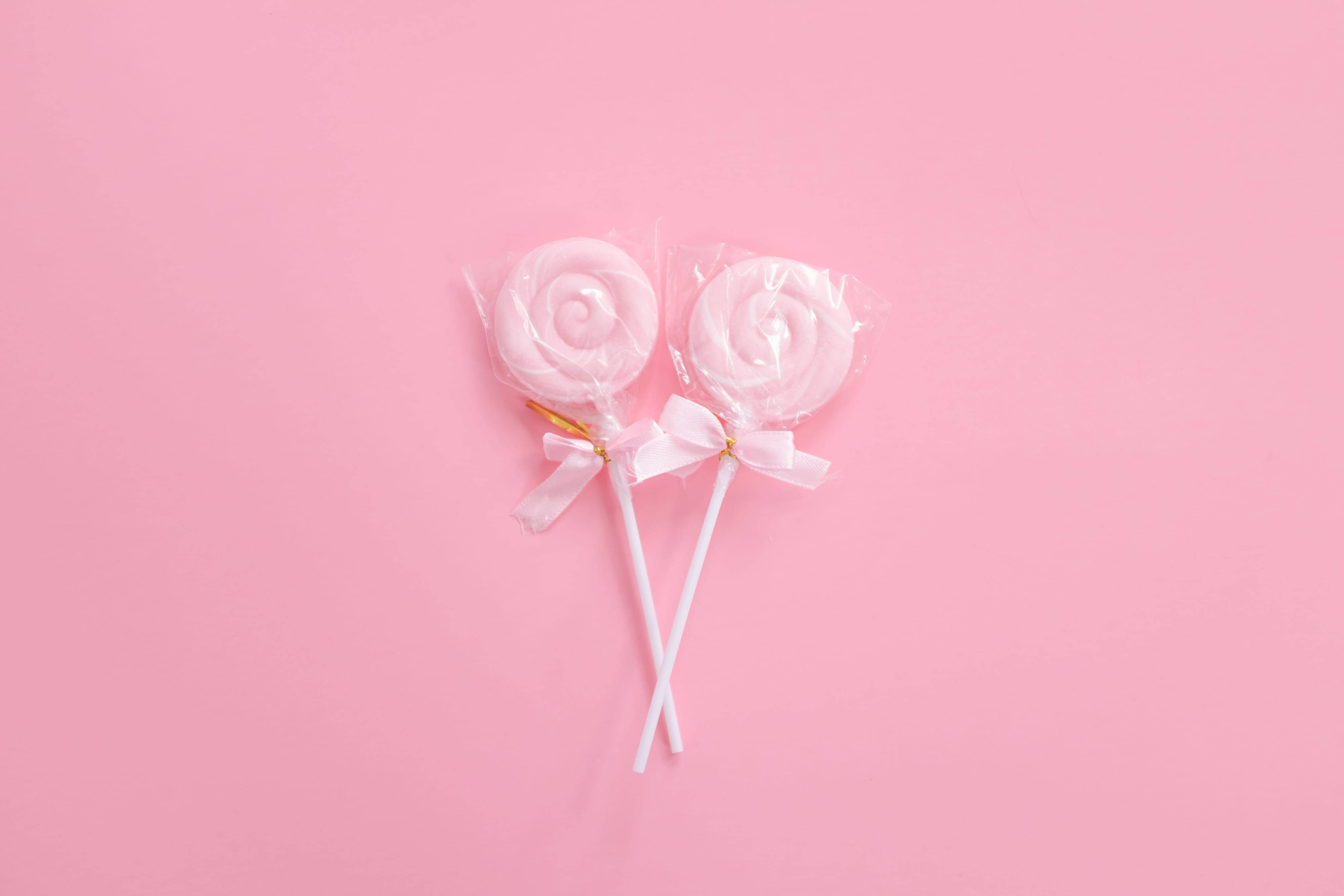 pink lollipops, white bows, soft pink background, 4K Desktop Wallpaper