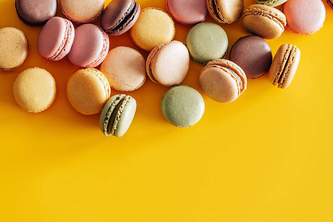 colorful macarons, pastel shades of pink green and beige, vibrant yellow background, SD Desktop Wallpaper