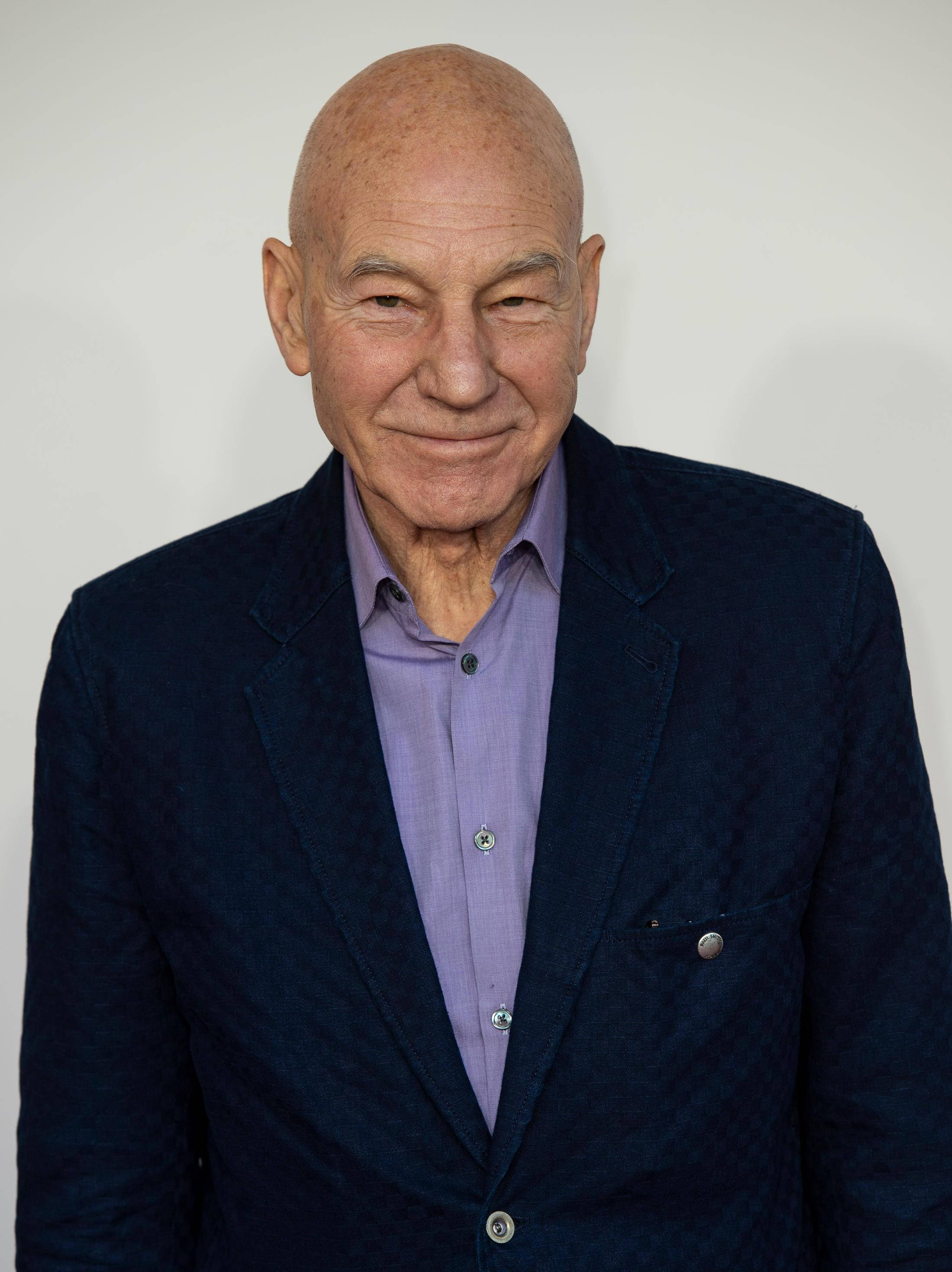 Patrick Stewart, bald older man, dark blue textured blazer, 2K Phone Wallpaper