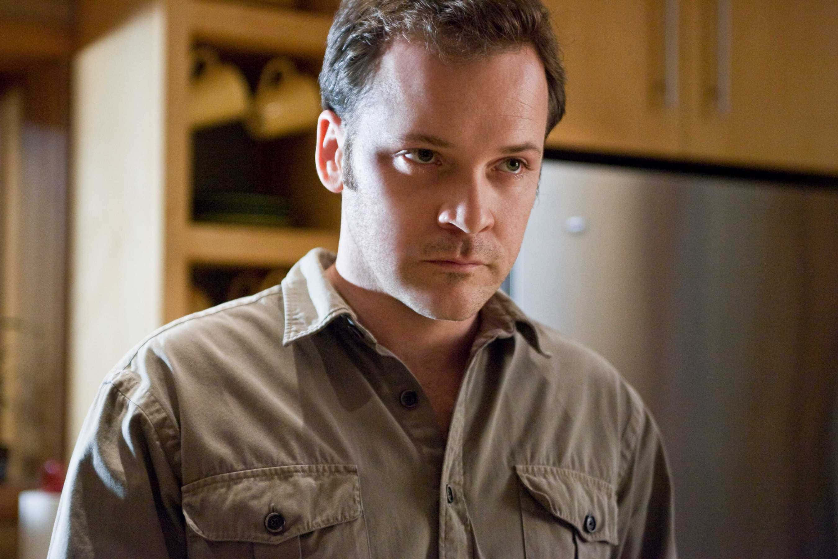 Peter Sarsgaard, beige shirt, warmly lit kitchen, 2K Desktop Wallpaper