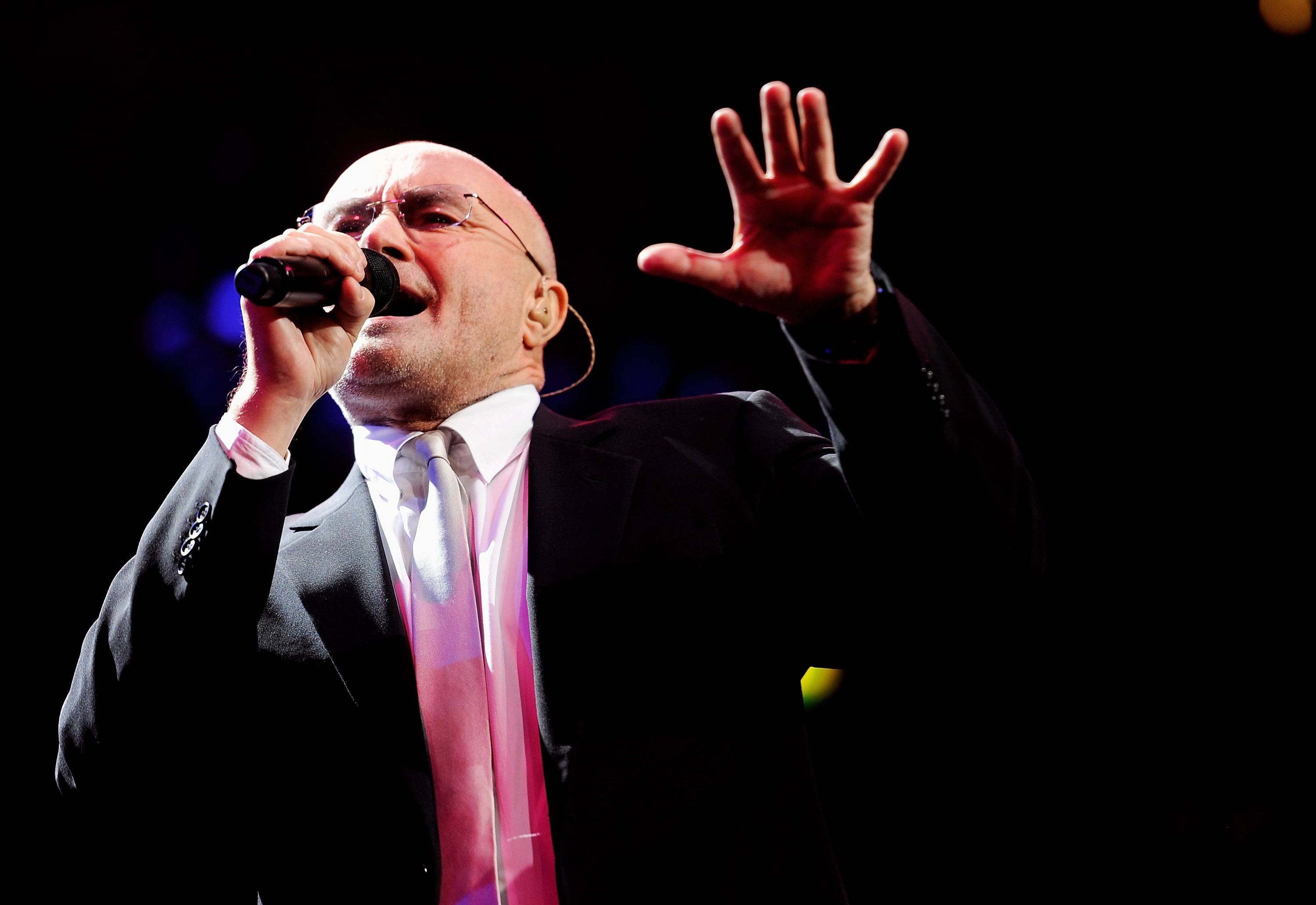 Phil Collins, black suit, pink tie, 2K Desktop Wallpaper