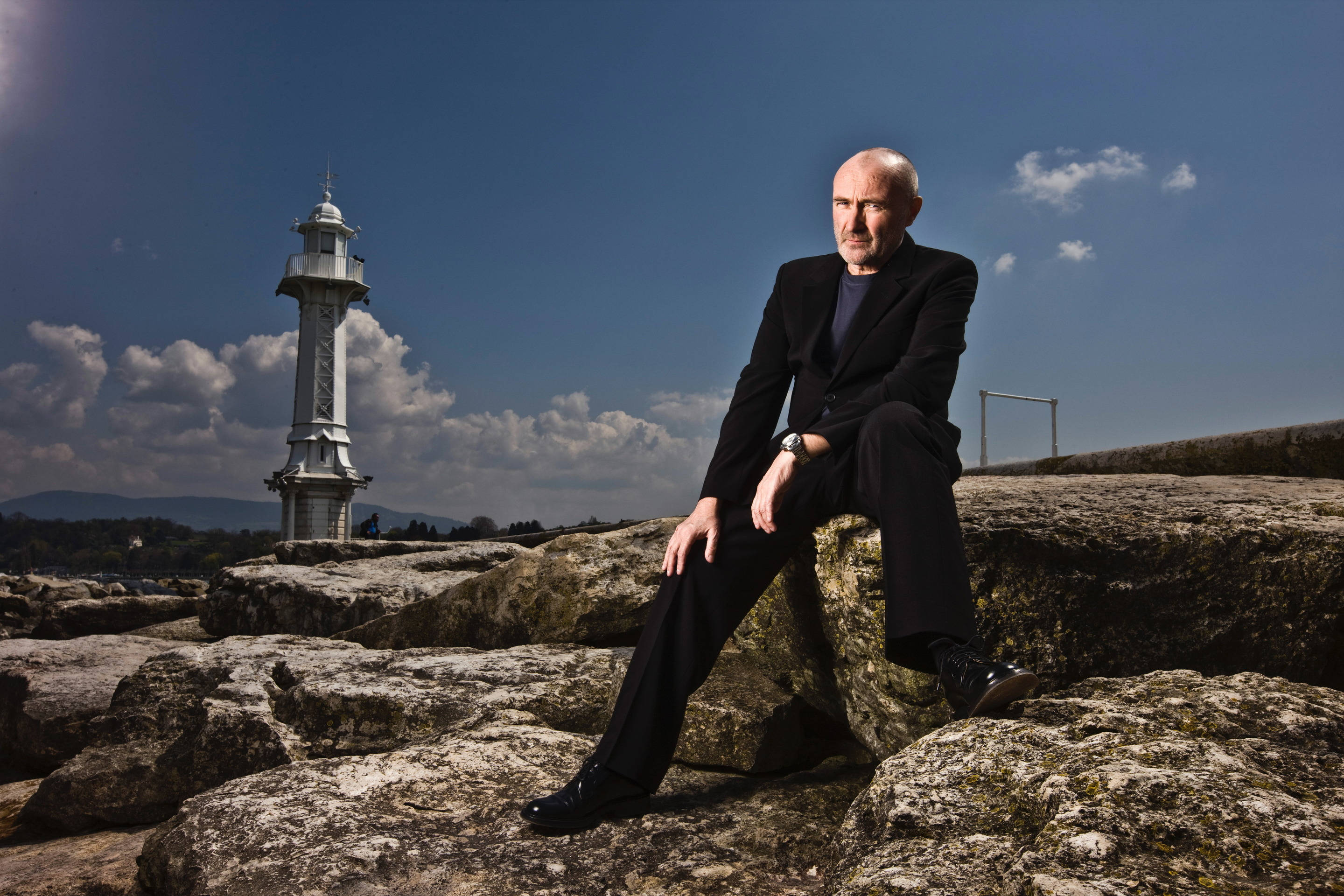 Phil Collins, black suit, white lighthouse, 2K Desktop Wallpaper