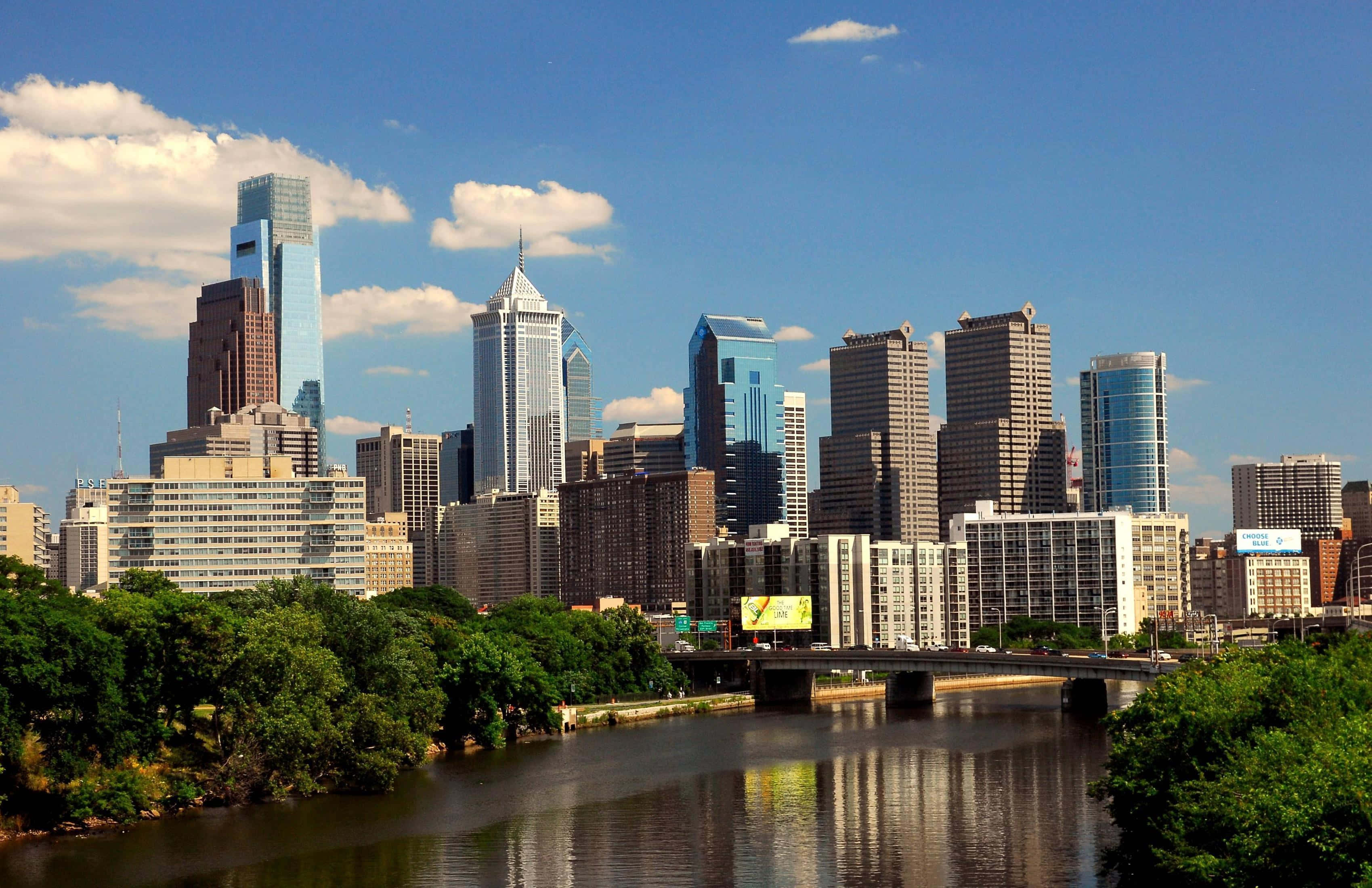 Philadelphia skyline, glass skyscrapers, lush green trees, 2K Desktop Wallpaper