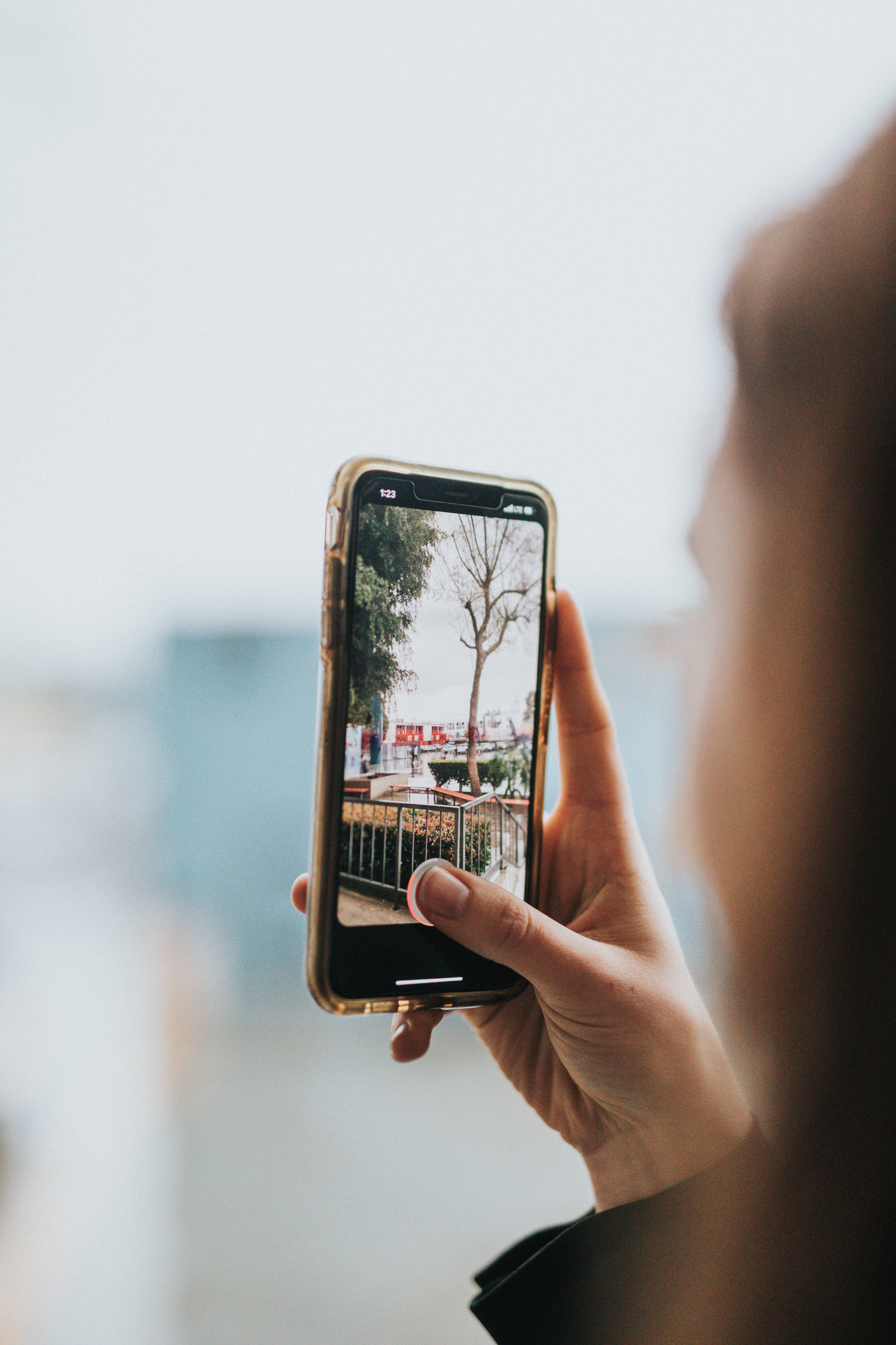 smartphone, photo of a tree-lined balcony, red signage, 5K Phone Wallpaper