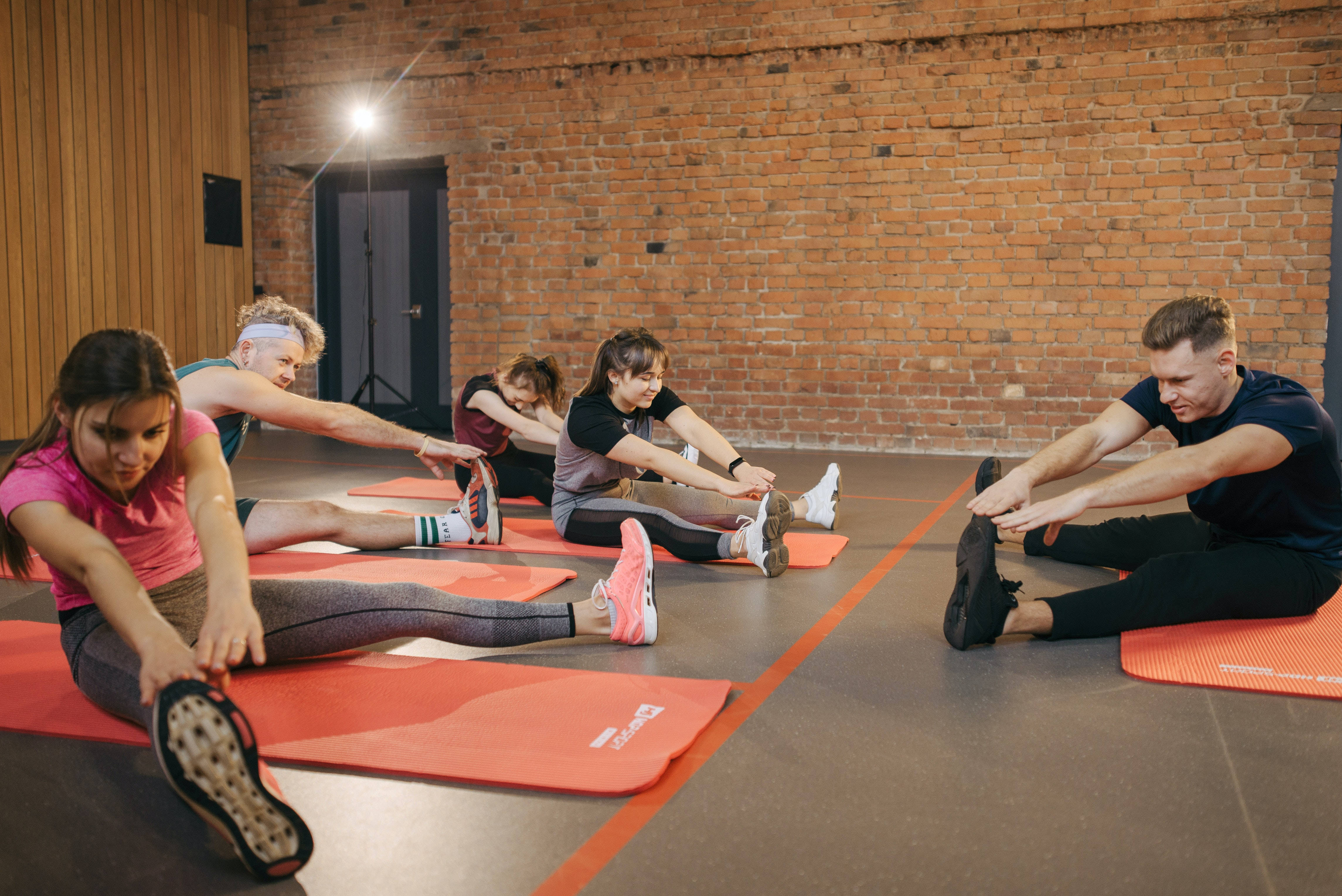 orange mats, rustic brick-walled fitness studio, bright overhead lighting, 4K Desktop Wallpaper